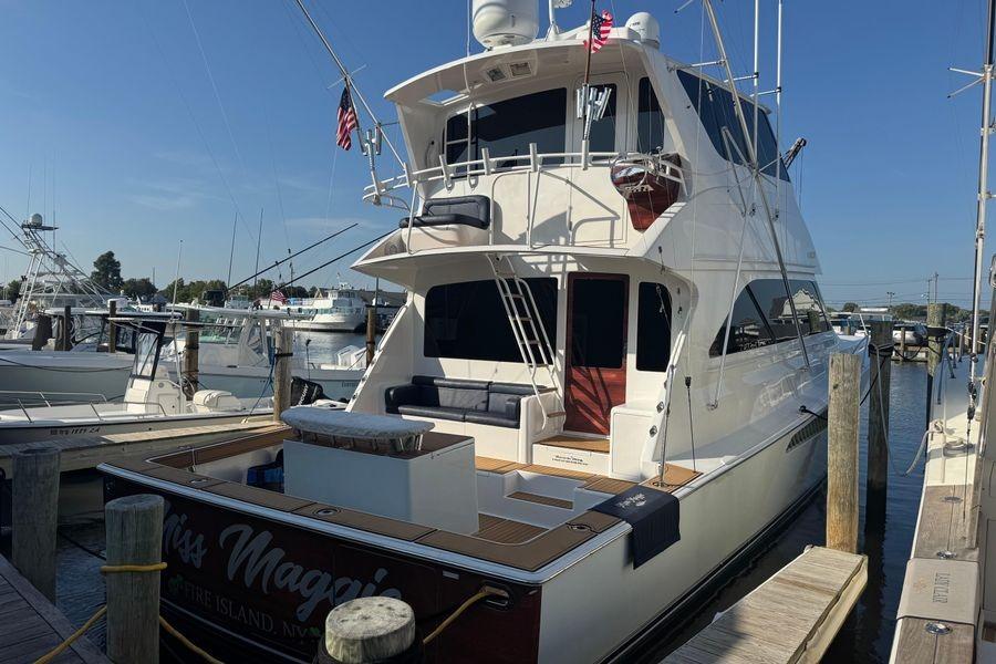 2002 Viking 61 Enclosed Bridge yacht docked at marina under clear blue sky.