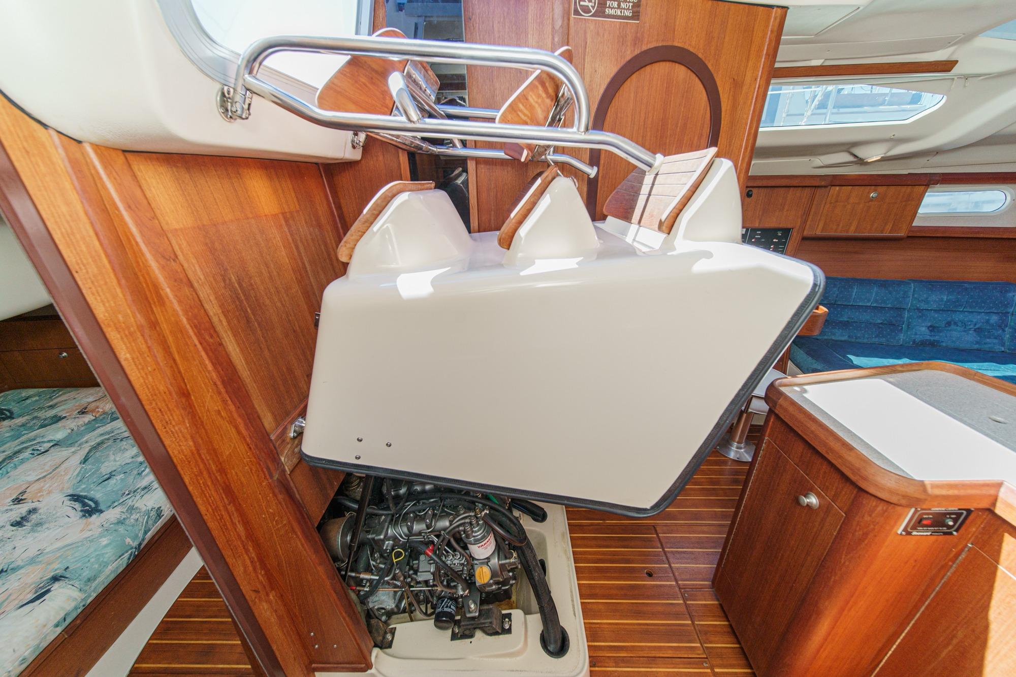 Interior of a 1996 Hunter 376 sailboat showing engine compartment and wooden cabinetry.