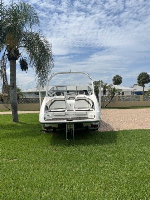 2015 Yamaha Boats 242 Limited S on grass with palm trees.