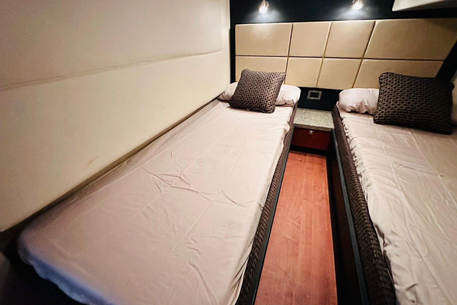 Twin beds in the 2008 Monterey 415 Sport Yacht cabin, featuring modern decor.
