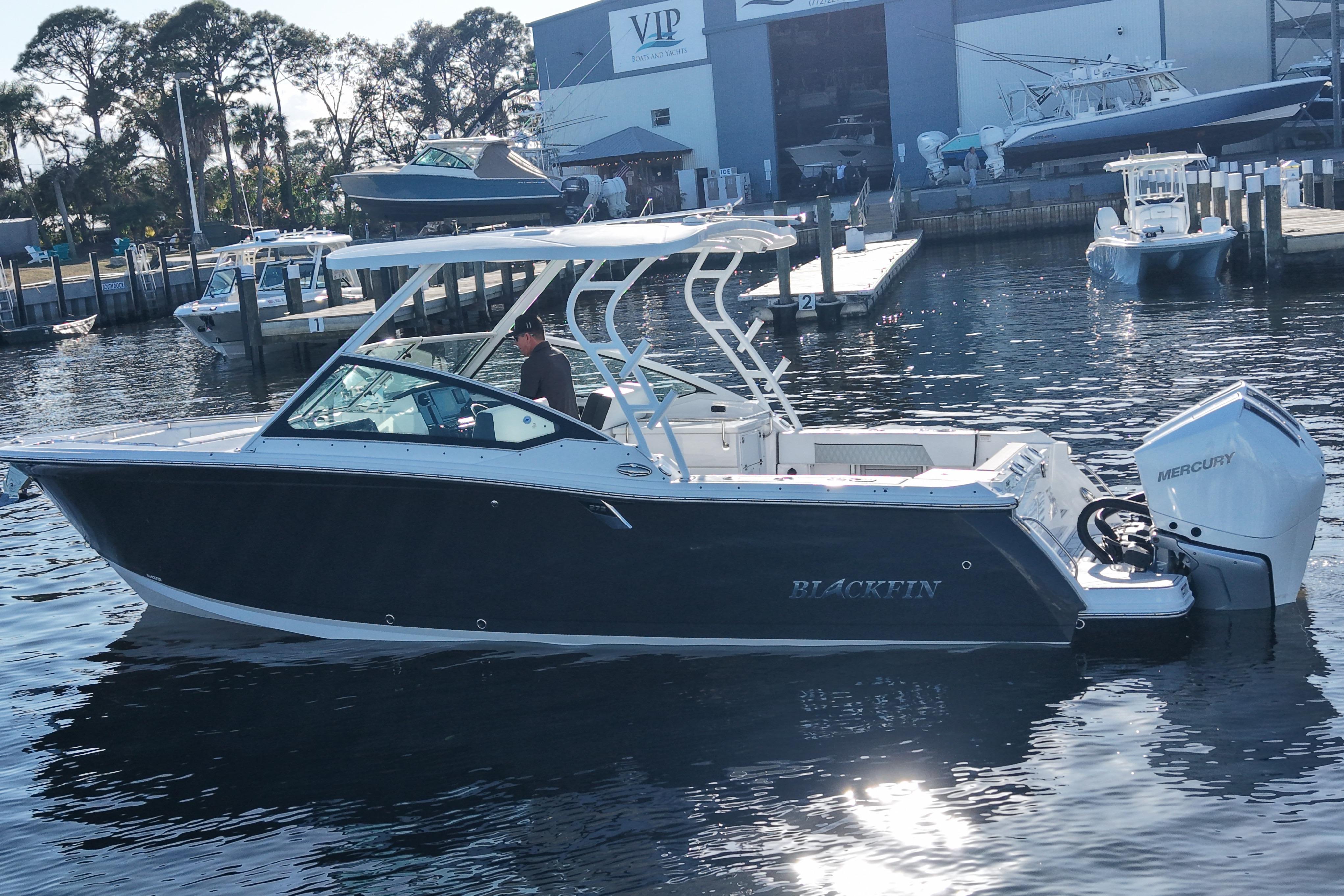 2025 Blackfin 272 DC boat on water near marina, featuring Mercury engine.