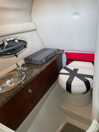 2019 Crownline E255 boat interior with sink and taped toilet.