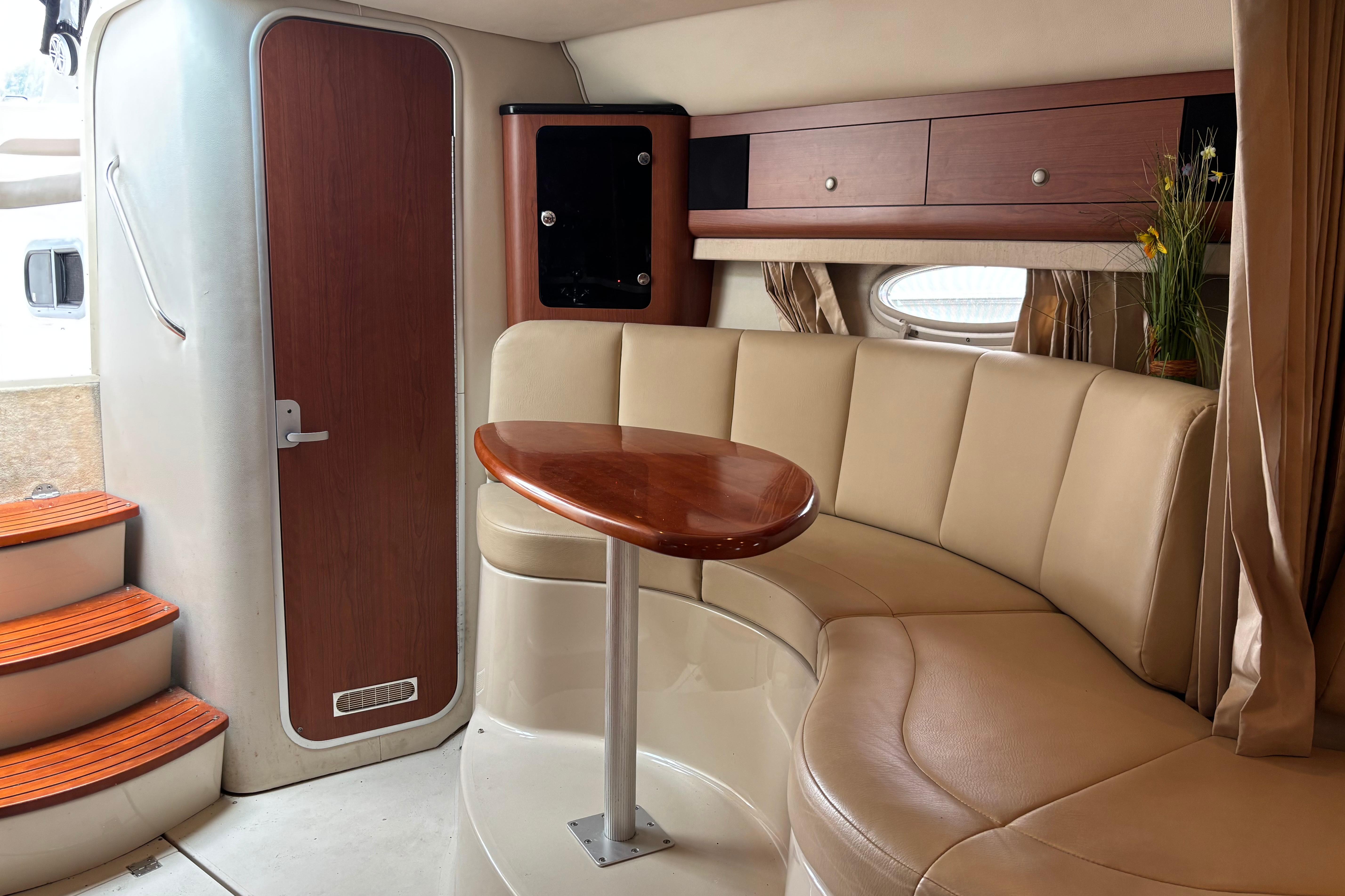 Interior of 2004 Chaparral Signature 330 yacht with curved seating and wooden table.