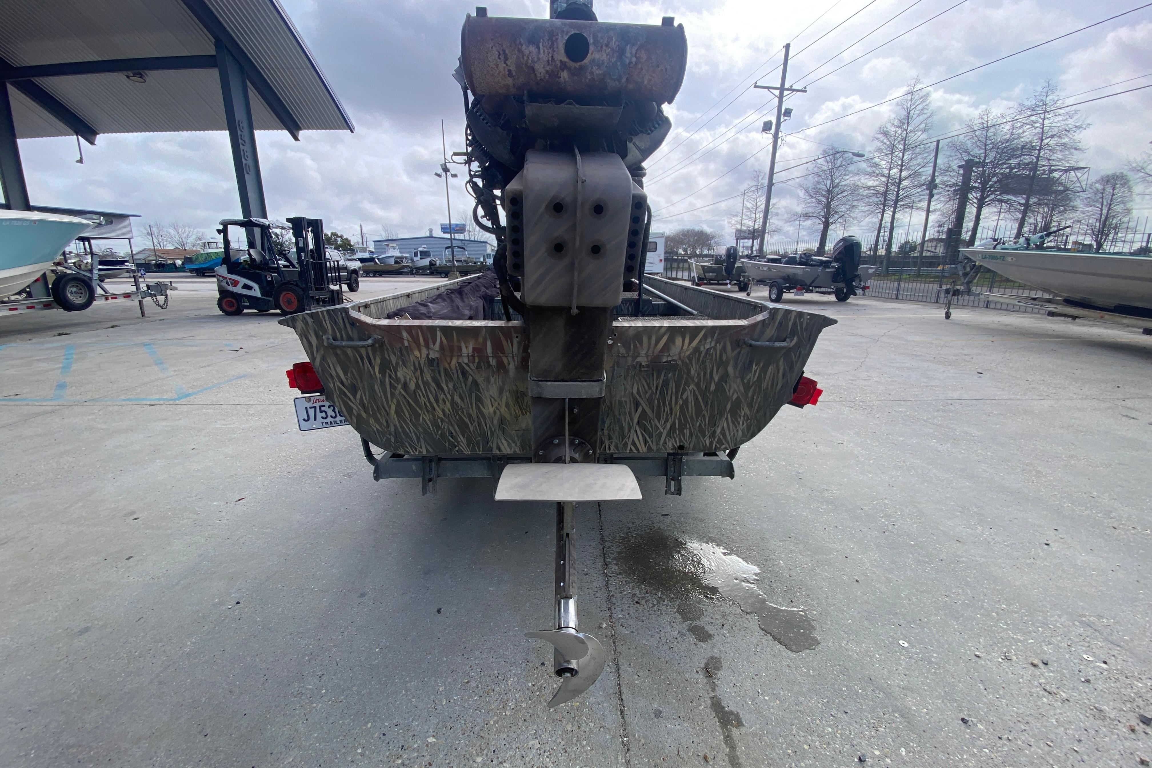 2009 Gator Trax MUD BUDDY 17 X 50 boat with camo design, parked outdoors.