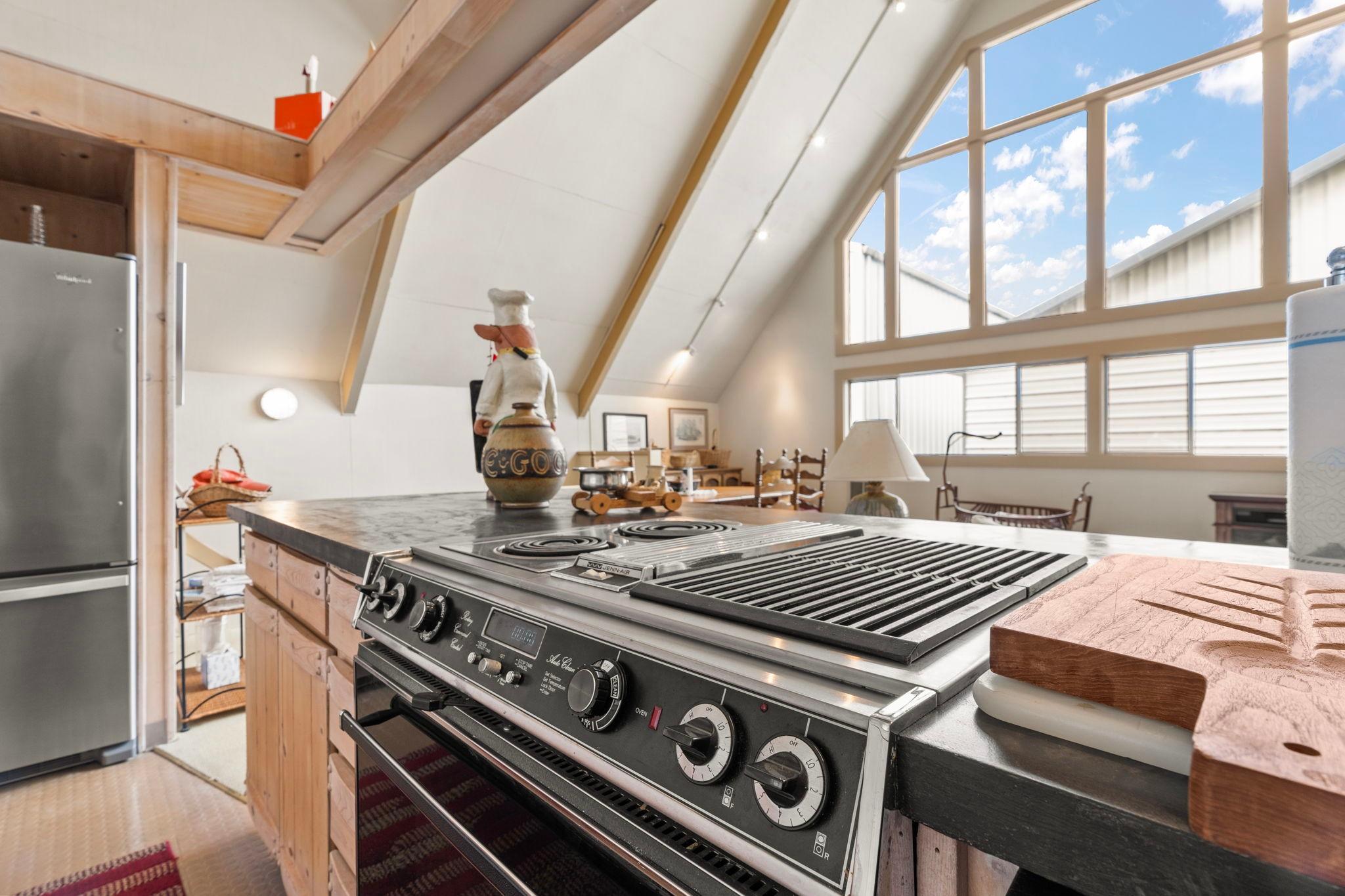 A-frame boathouse kitchen with modern appliances and large windows, built in 1976.