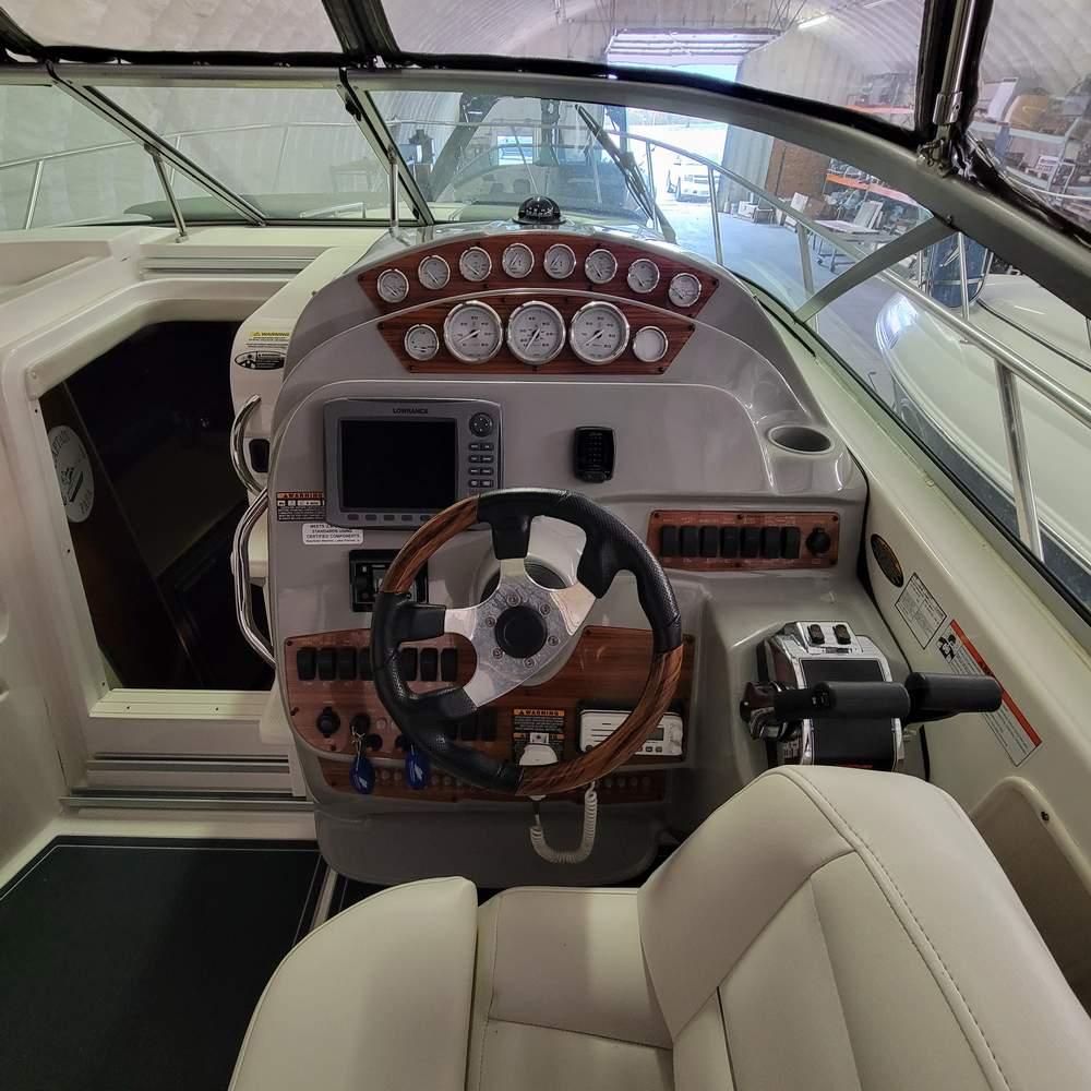 2010 Bayliner 335 boat helm with gauges, steering wheel, and control panel in a cabin setting.