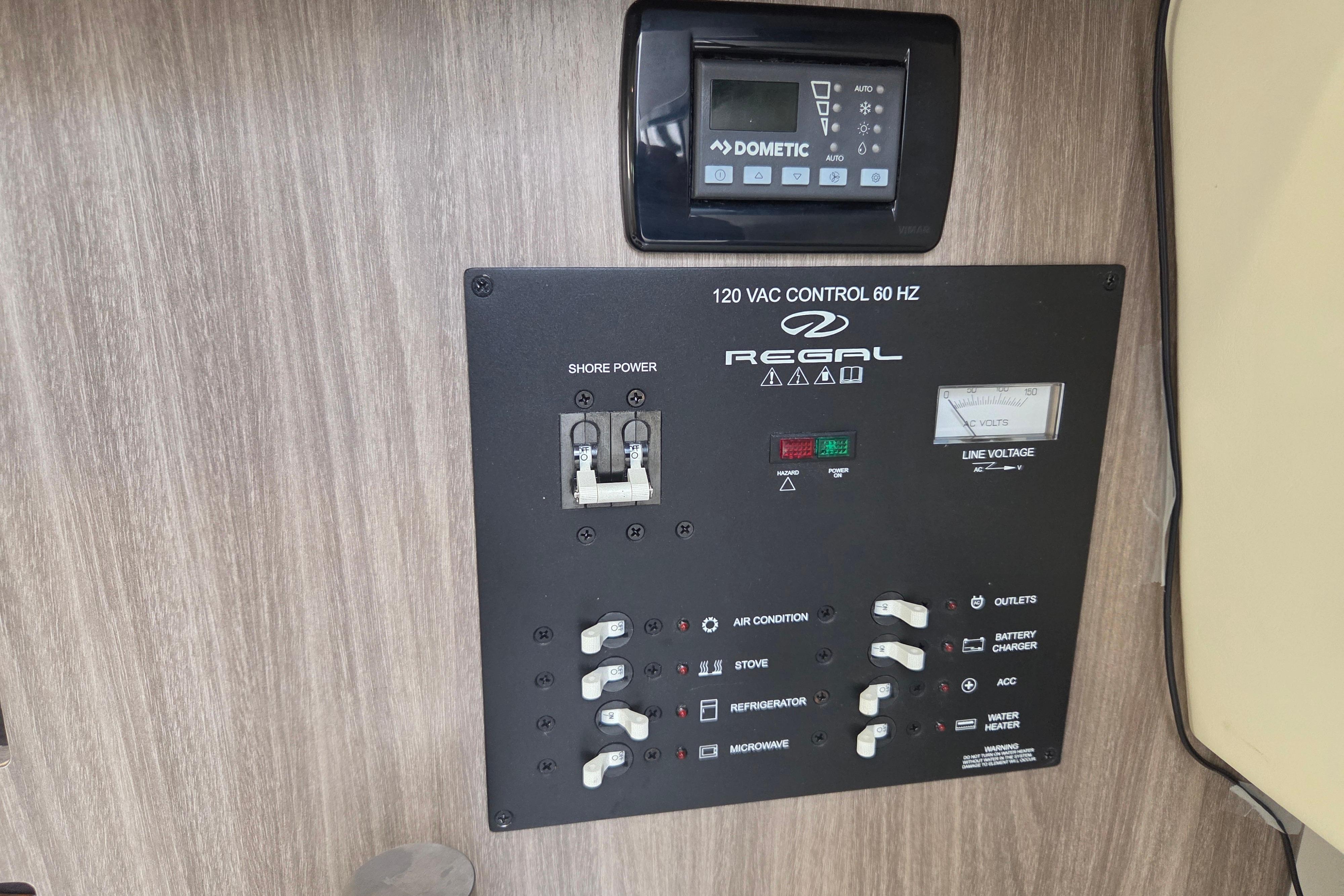 Control panel of a 2021 Regal 26 Express boat with various switches and a Dometic display.