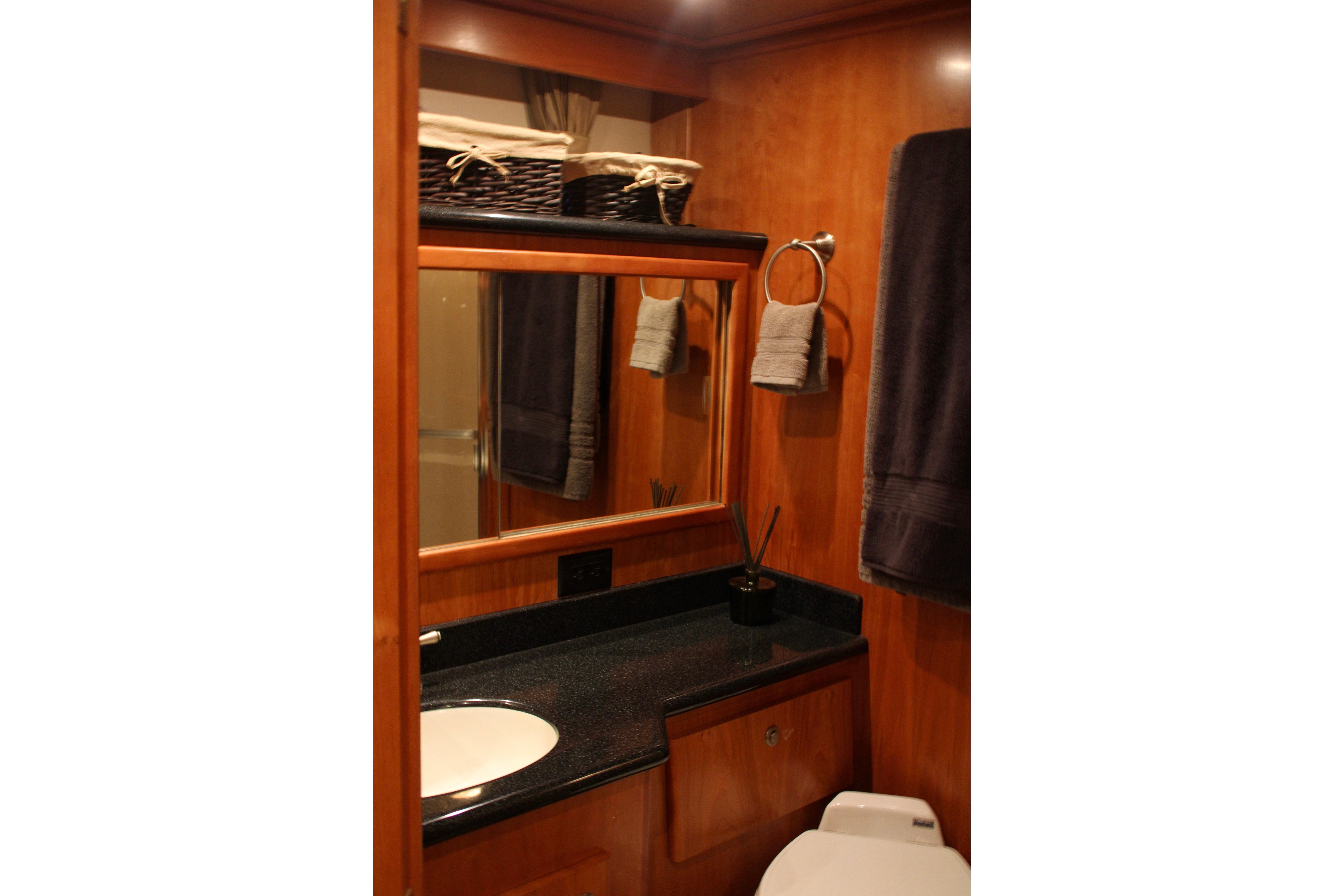 Luxurious bathroom in 2007 Navigator 5100 yacht with wooden cabinetry and modern fixtures.