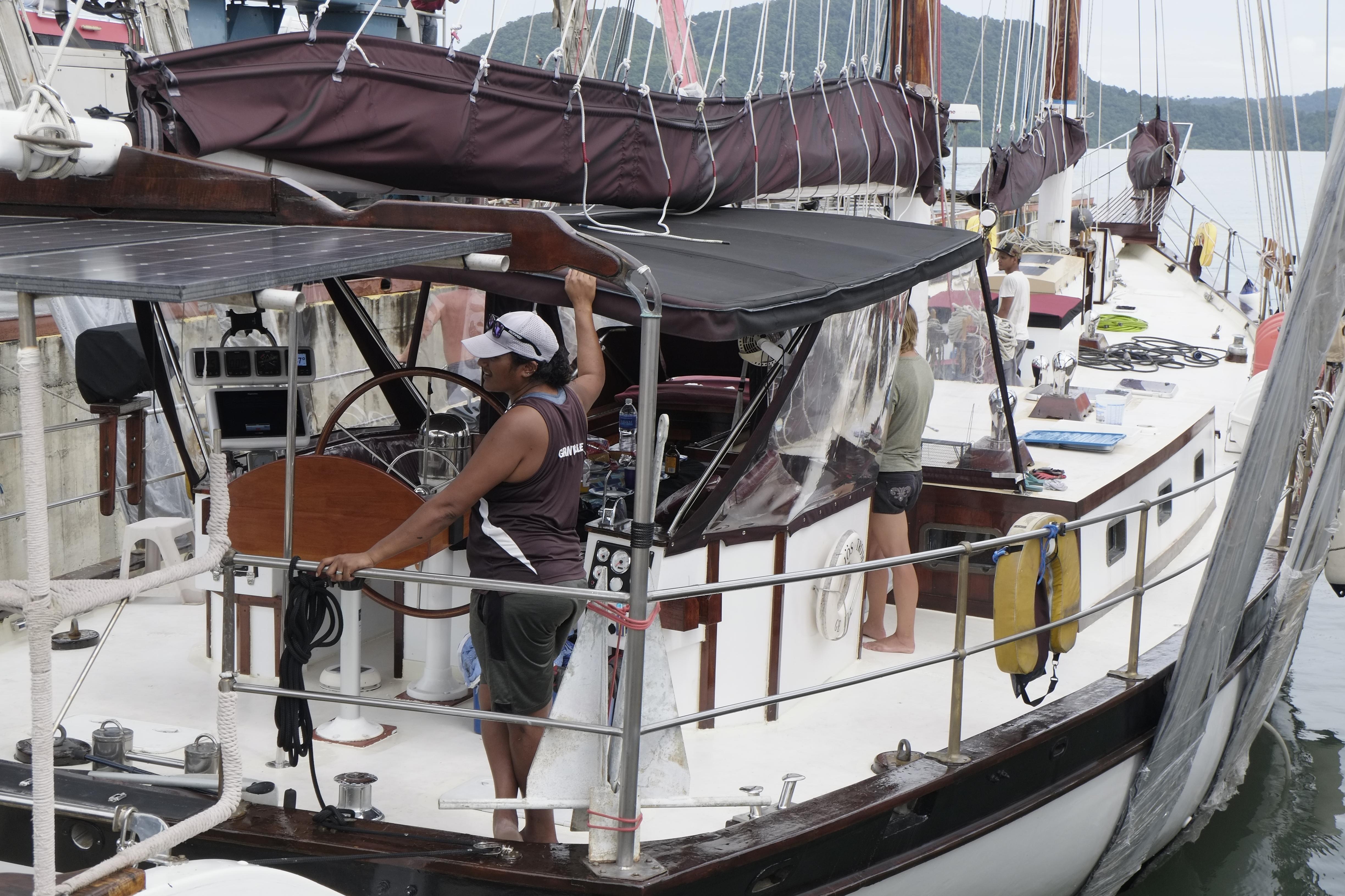 Custom Bud Macintosh schooner, 2006, docked with crew on deck, featuring solar panels and canopy.
