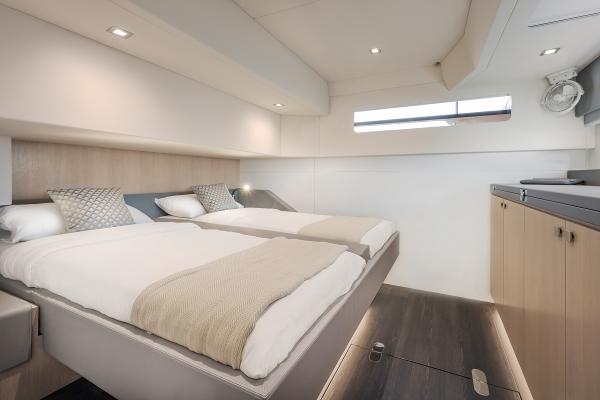 Luxurious cabin interior of 2025 Privilege Signature 650 yacht with twin beds and modern decor.