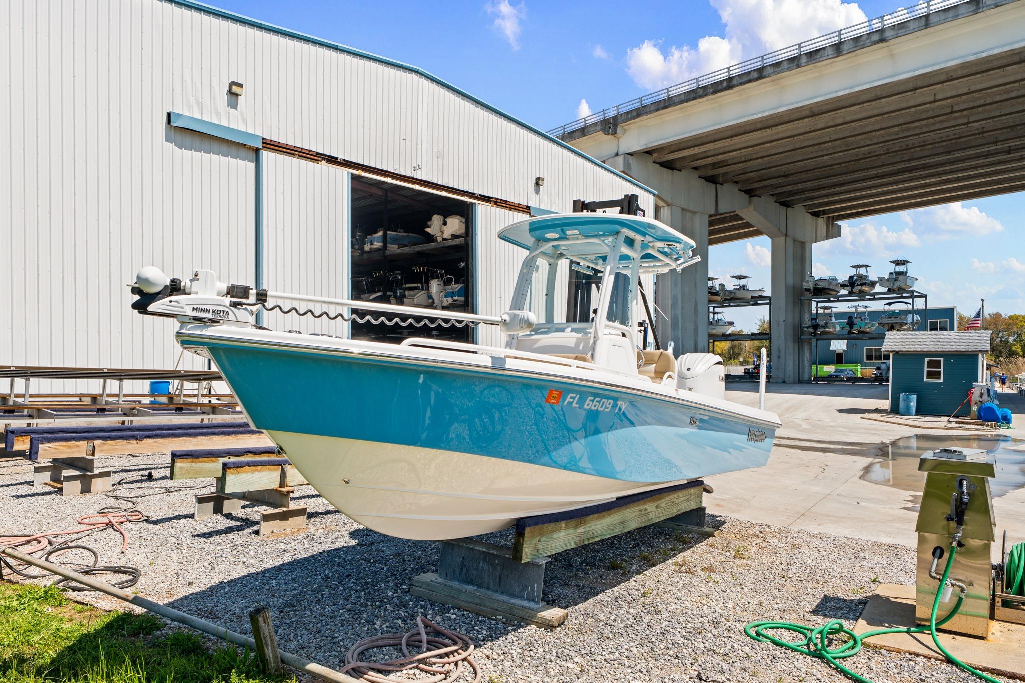 2023 Everglades 243 Center Console boat displayed outdoors near a marina facility.