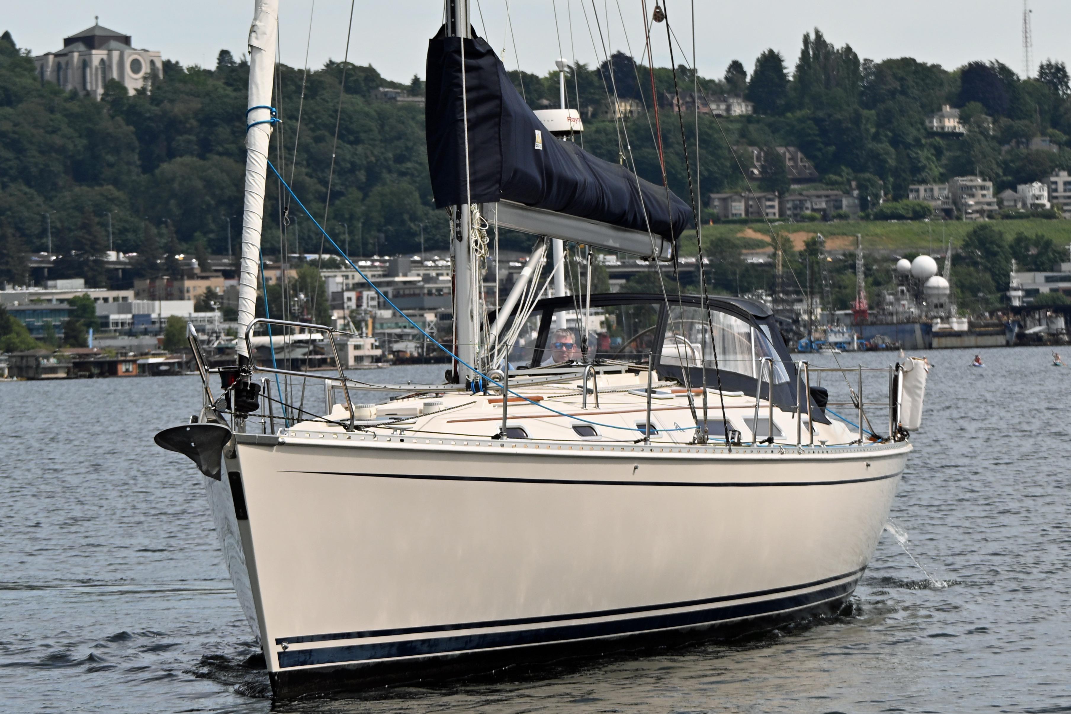 2004 Hanse 411 sailboat cruising on a calm lake with a scenic backdrop.