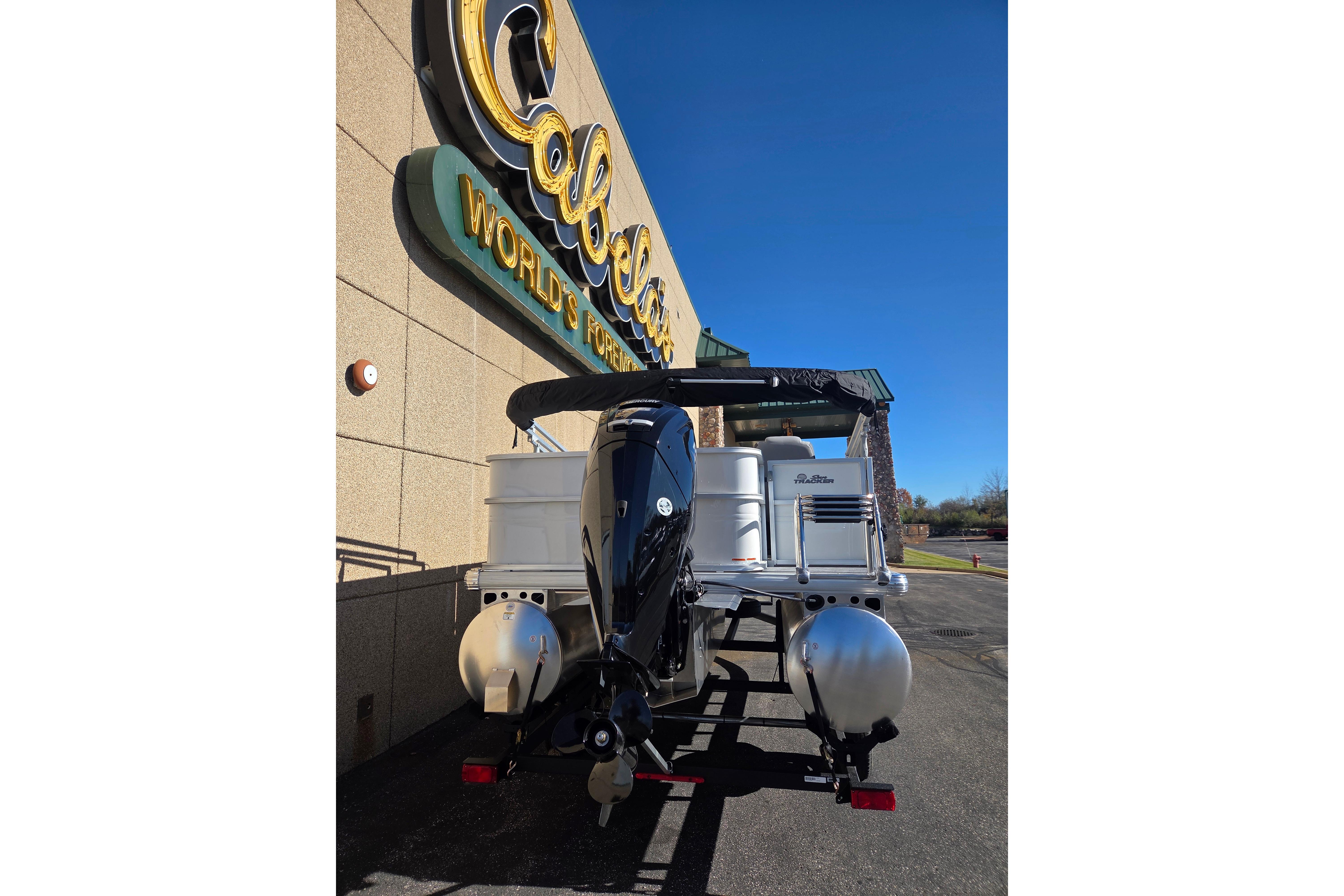 2026 Sun Tracker Party Barge 18 DLX at Cabela's store entrance.