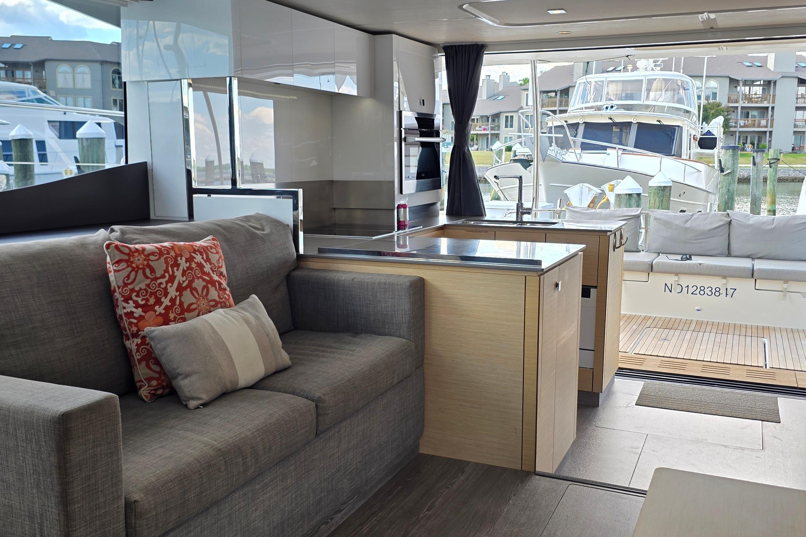 Modern interior of 2018 Fountaine Pajot Motor Yacht 44 with cozy seating and marina view.