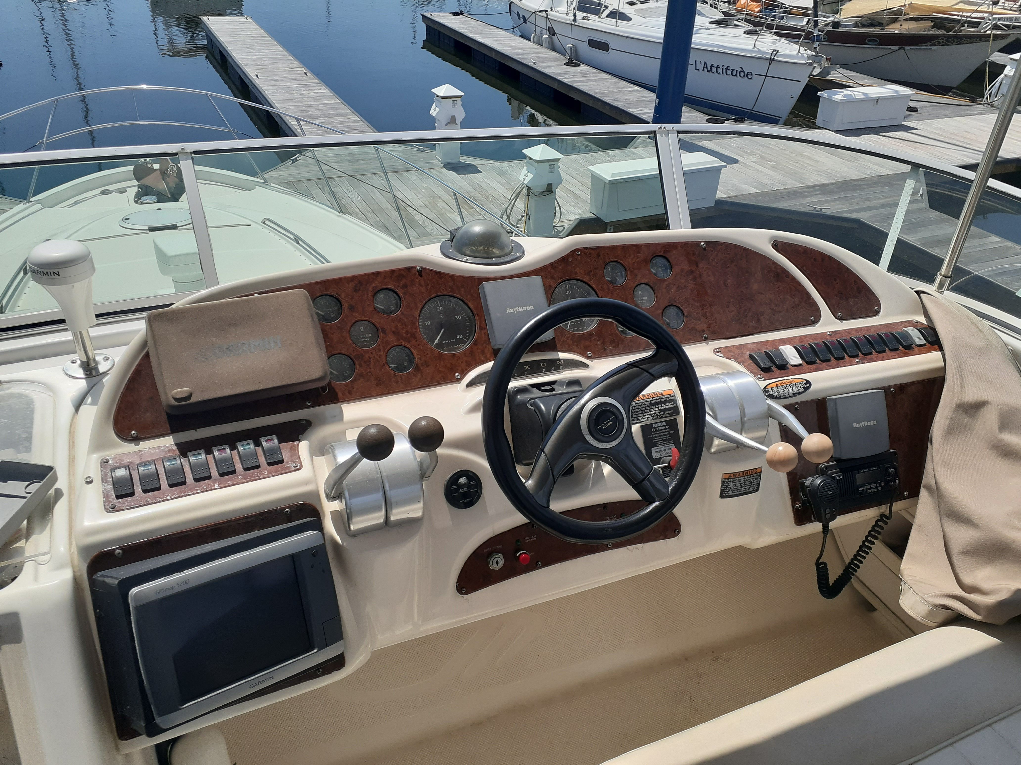 The image shows the helm of a 2000 Maxum 4600 SCB with wood paneling and modern instruments.