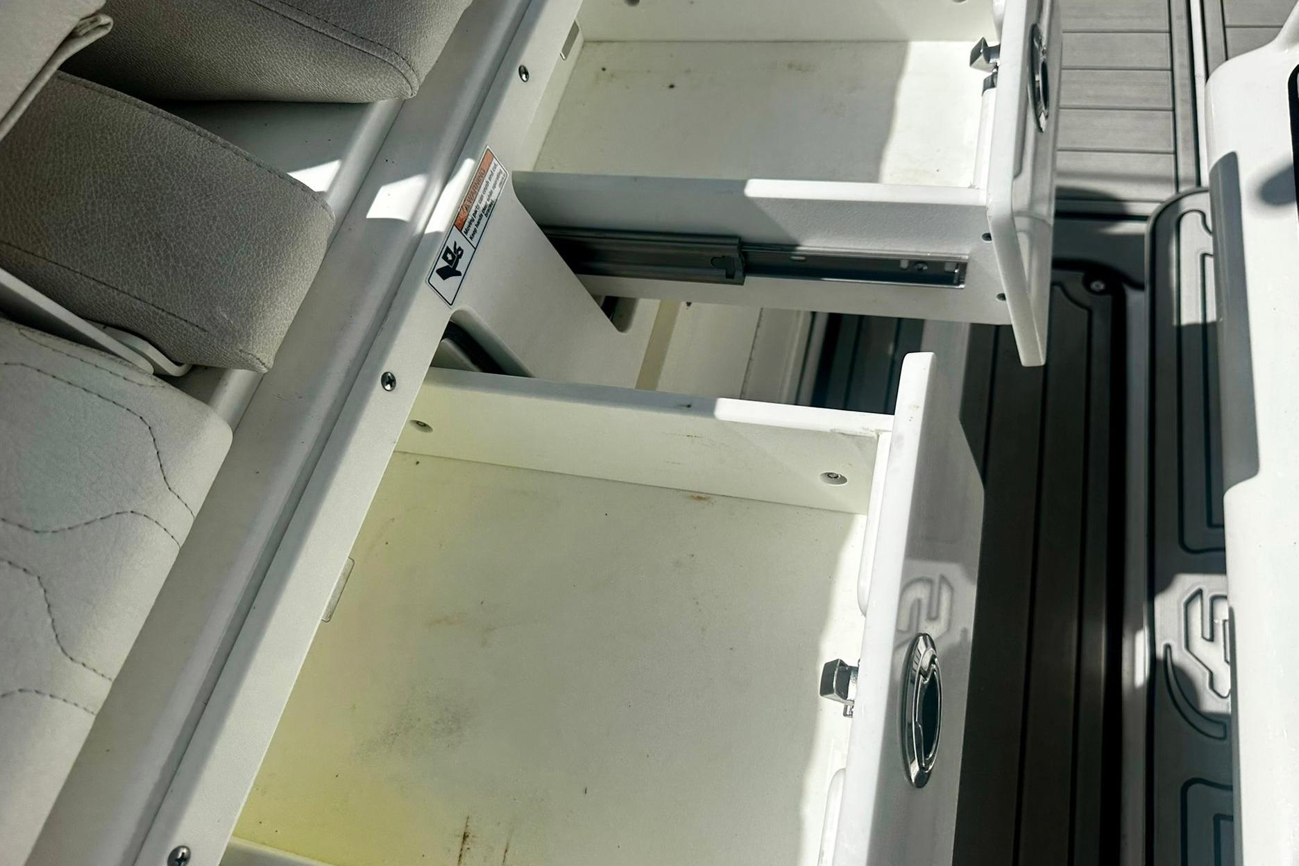 Open storage drawers on a 2002 Sea Fox 228 Commander boat, showcasing interior space.