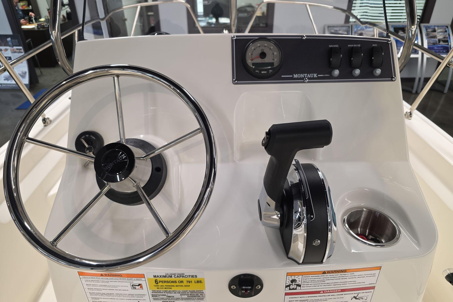 2026 Boston Whaler 150 Montauk boat console with steering wheel and controls.