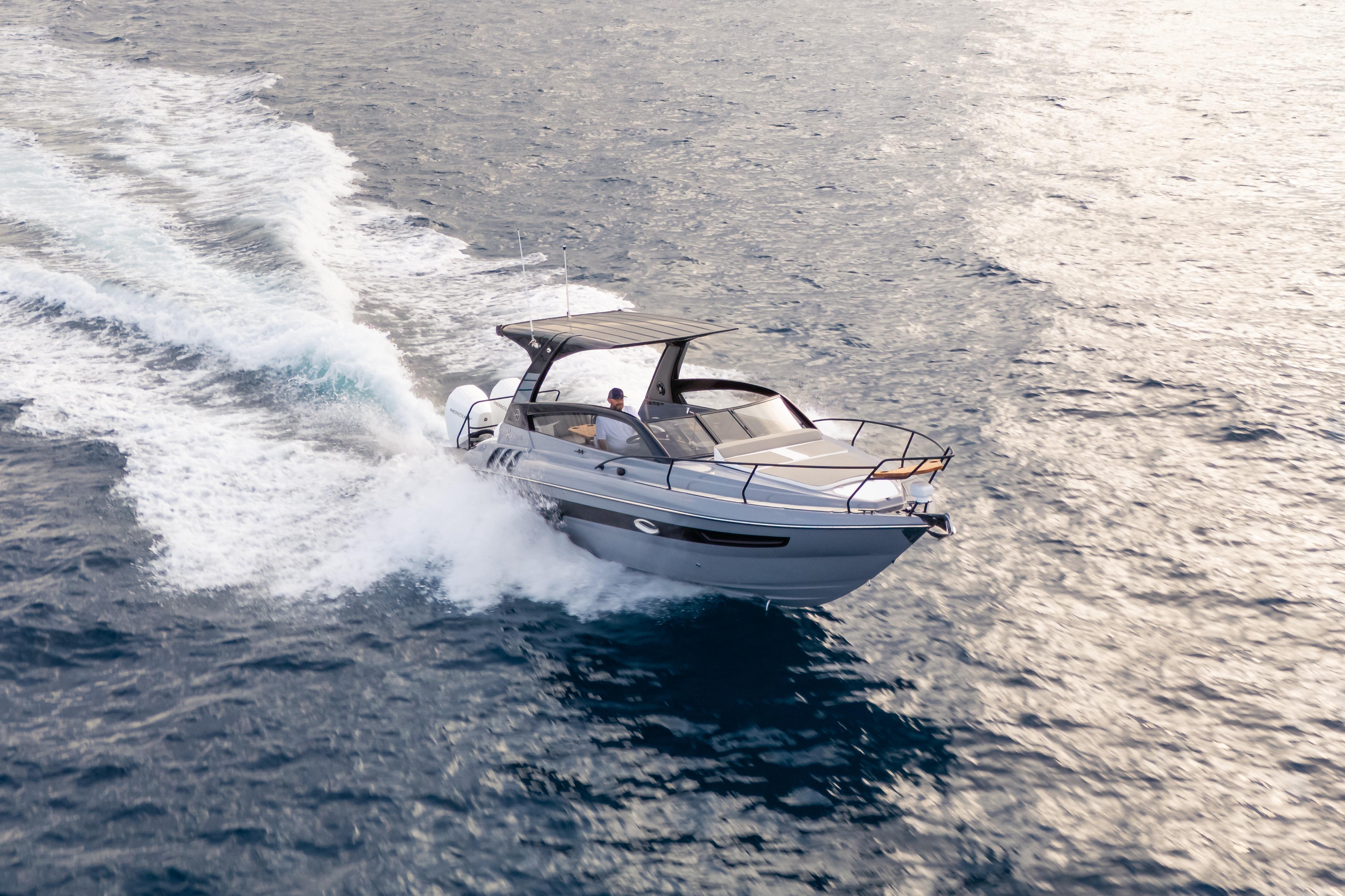 2026 Hanover 305 boat cruising on open water, creating a dynamic wake.