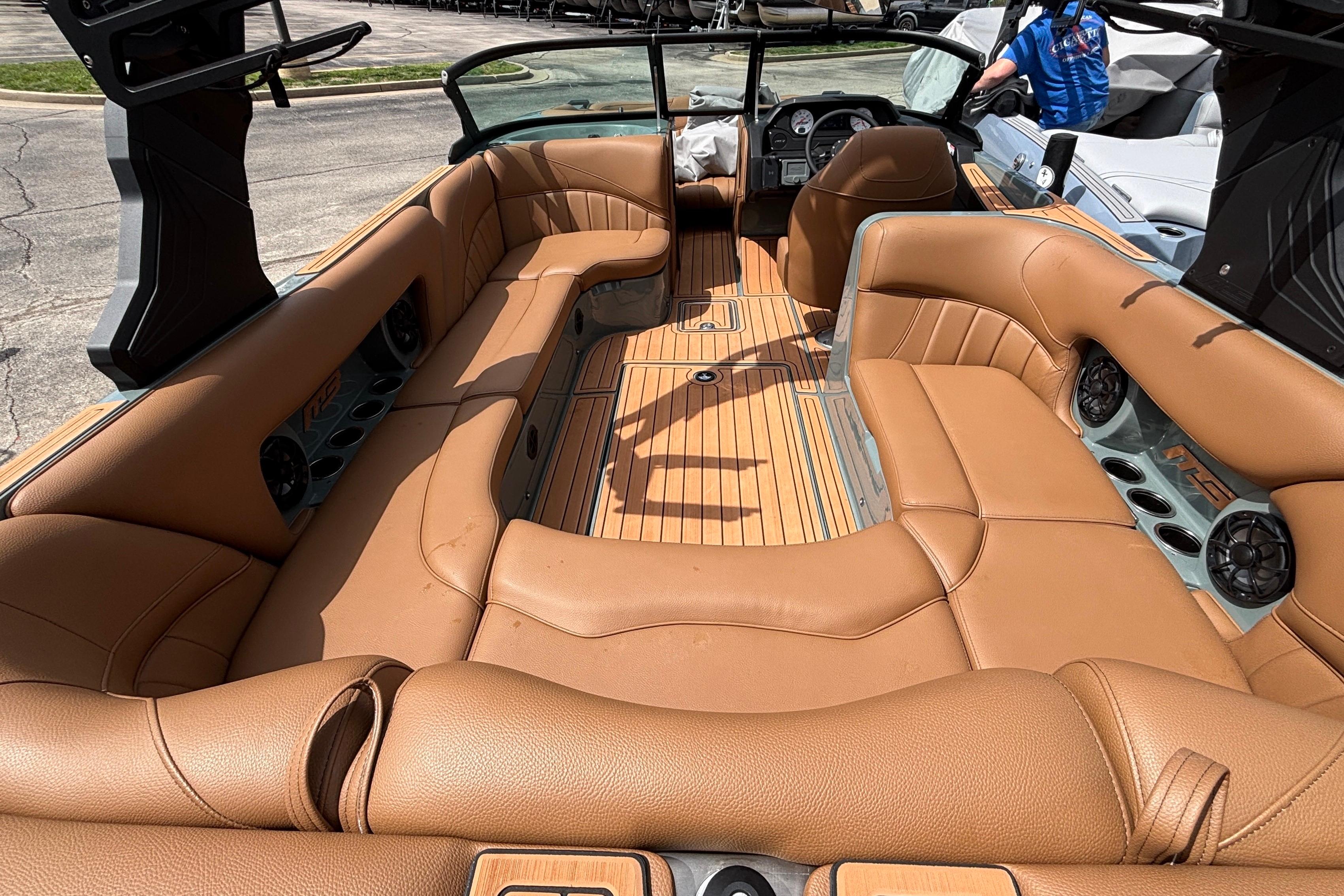 Interior of 2026 MB B52 23 Classic boat with tan leather seating and wood flooring.