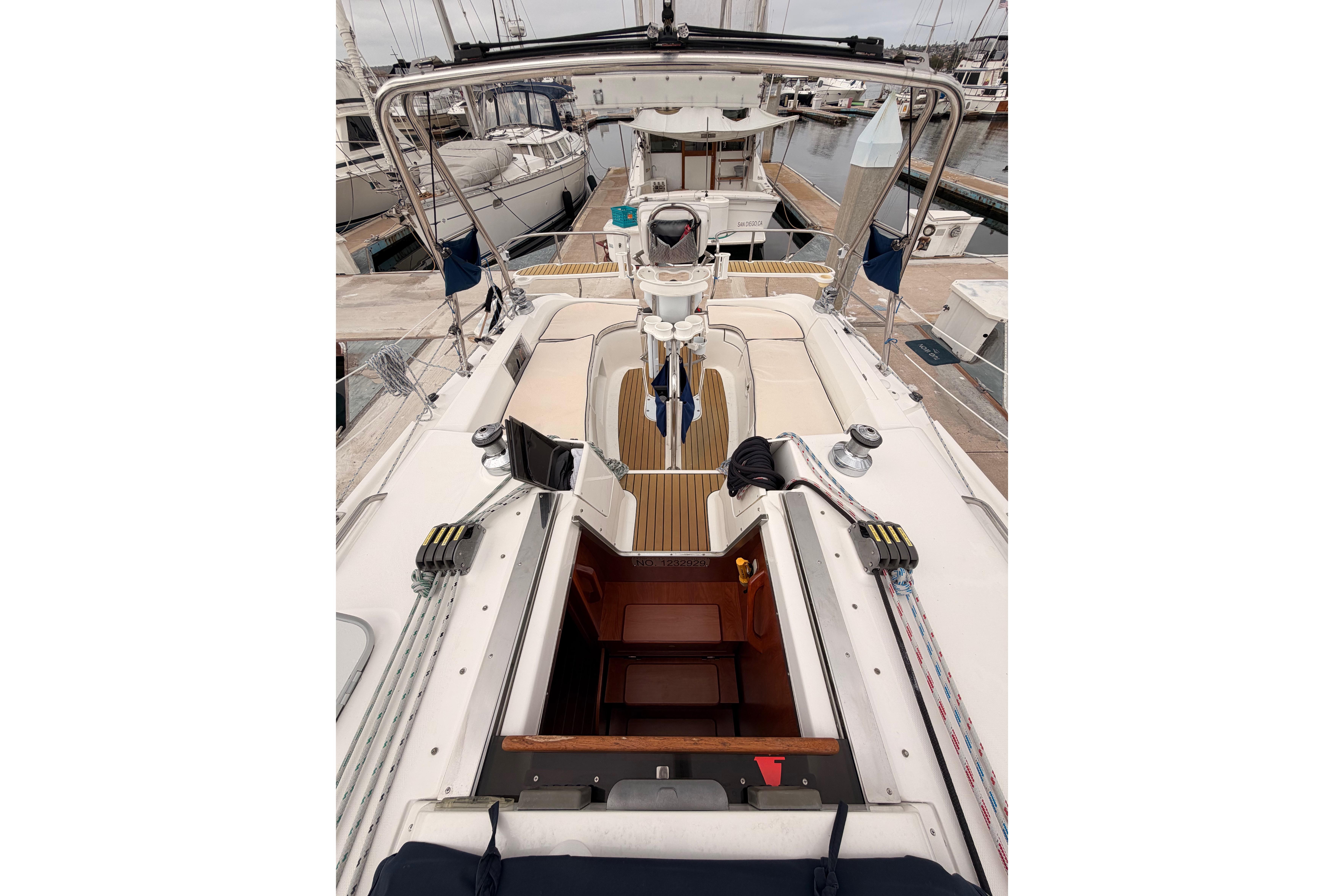 2009 Hunter 38 sailboat cockpit with open cabin, docked at marina.
