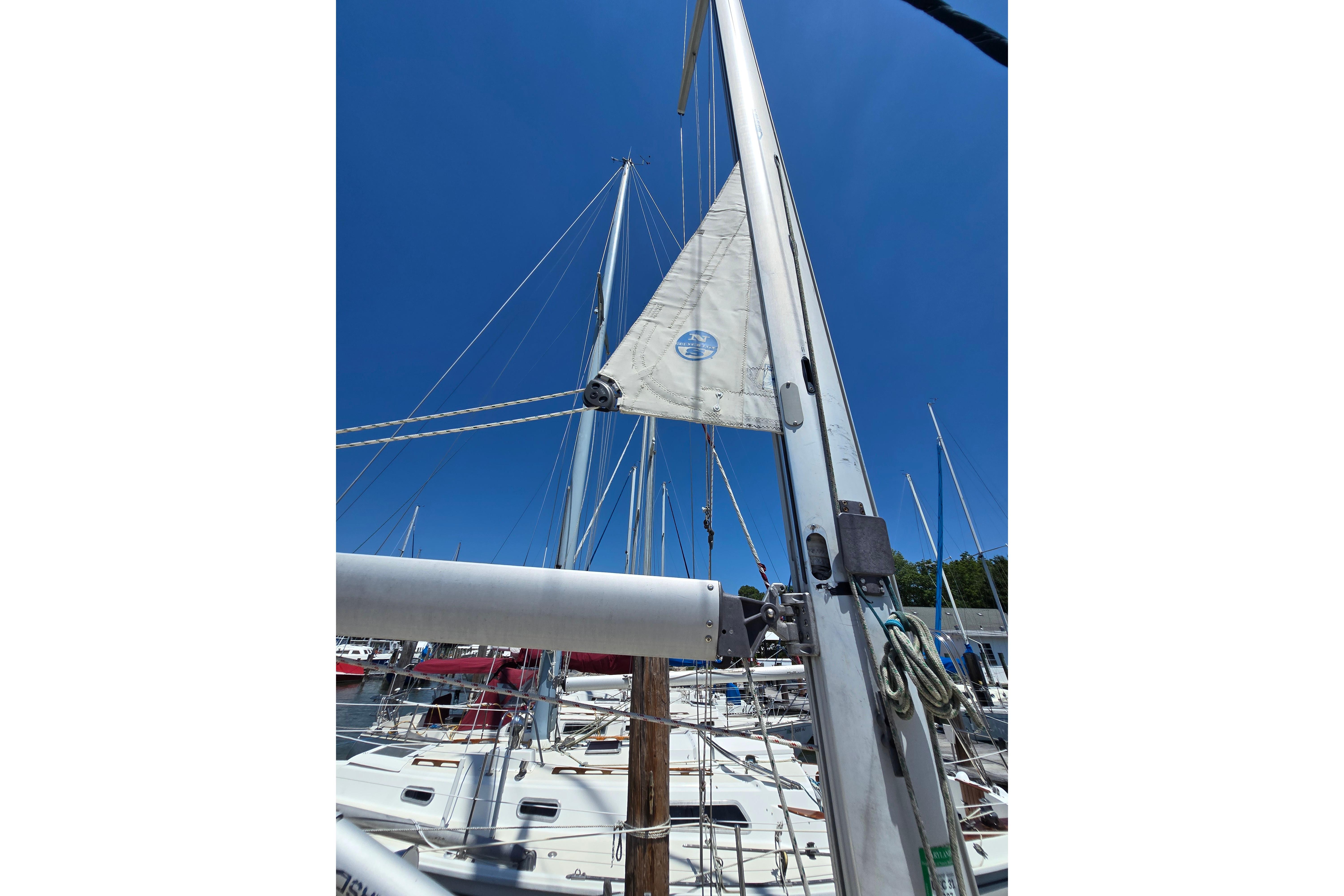 Sailboat mast and rigging of 1993 Caliber 35 under clear blue sky.