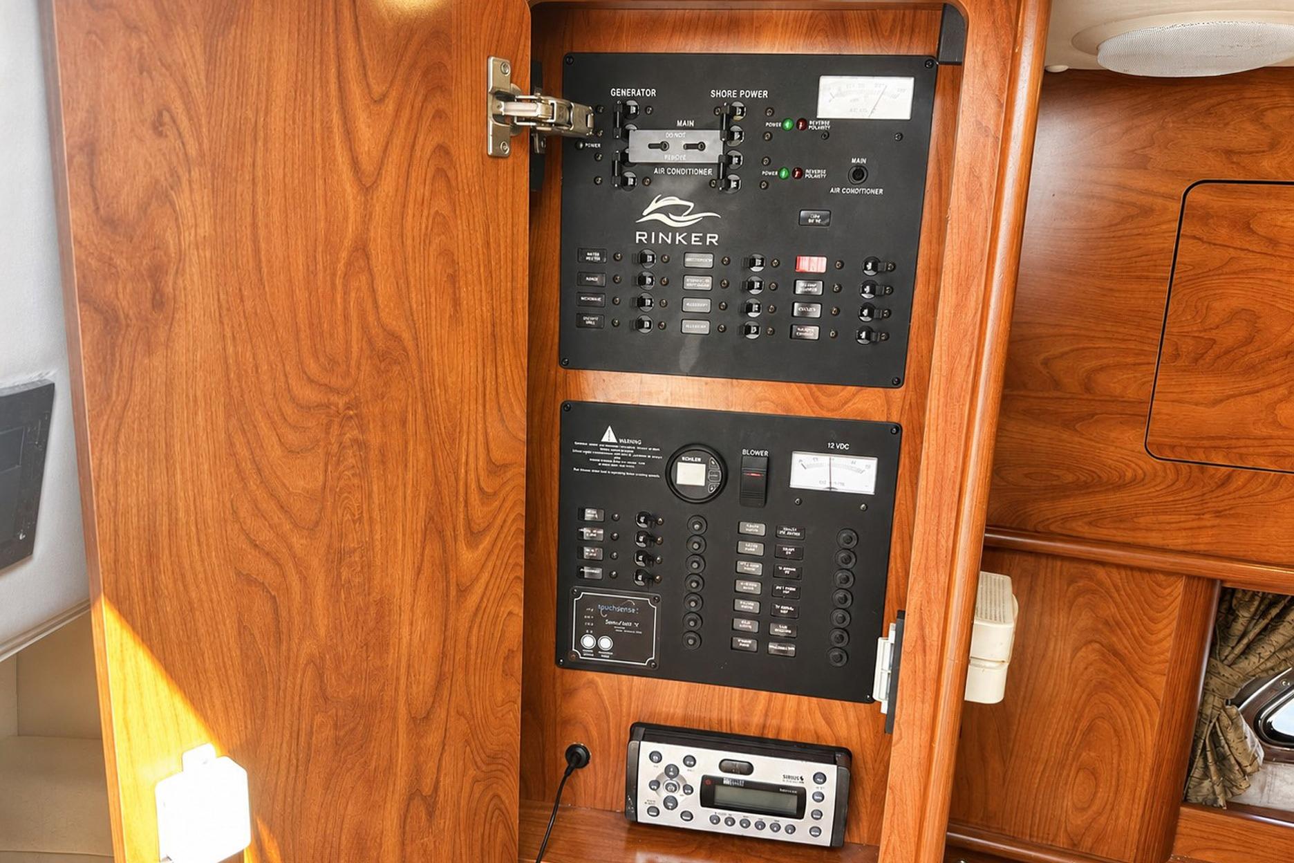 2012 Rinker 310 Express Cruiser LE electrical panel with wood finish.