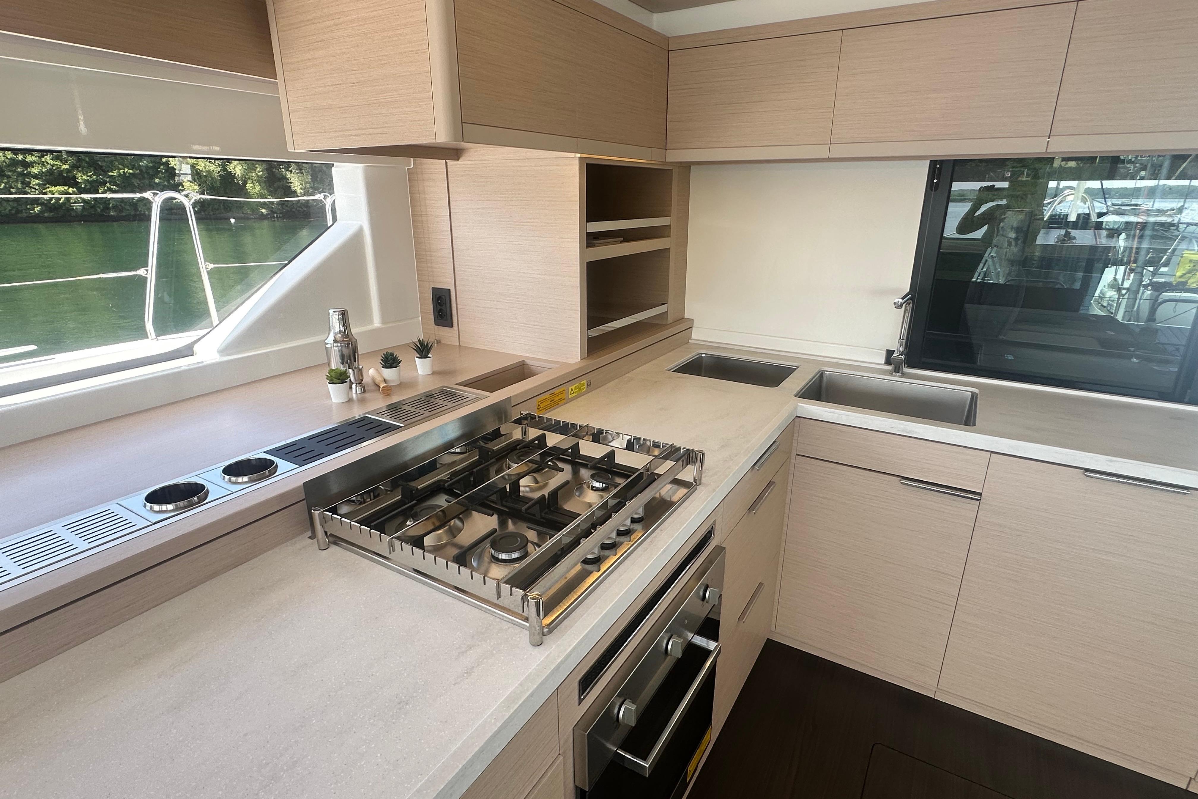 Modern kitchen interior of 2025 Lagoon 55 yacht with stove, sink, and ample counter space.
