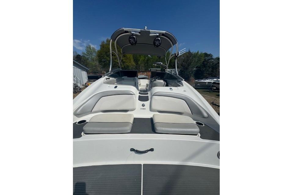 2012 Yamaha AR210 boat with seating and canopy under clear blue sky.