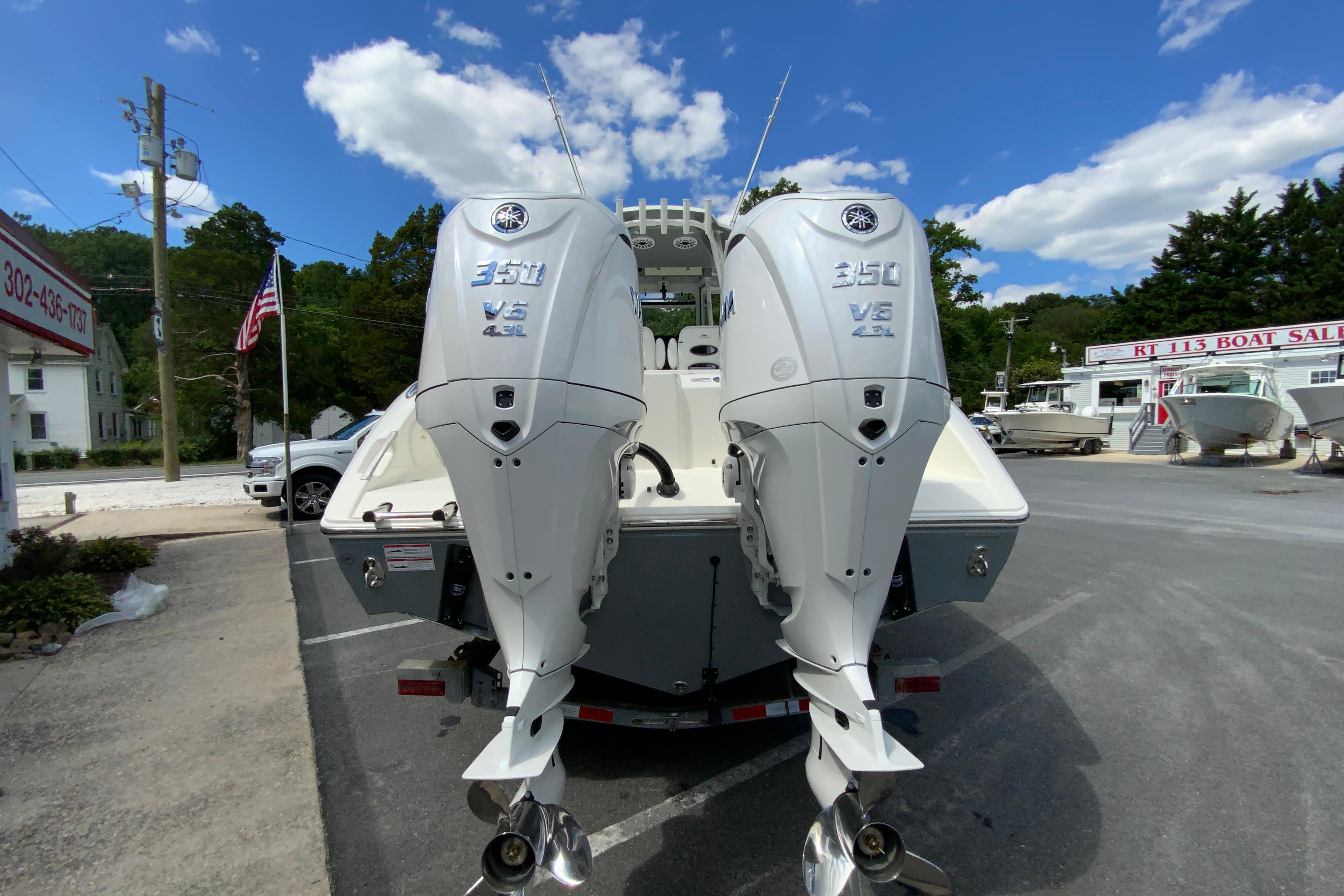 2027 Cobia 320 Center Console with twin Yamaha 350 V6 engines at a boat dealership.