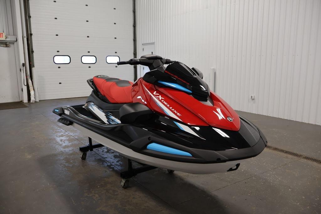 2026 Yamaha WaveRunner VX Deluxe in a showroom, featuring sleek red and black design.