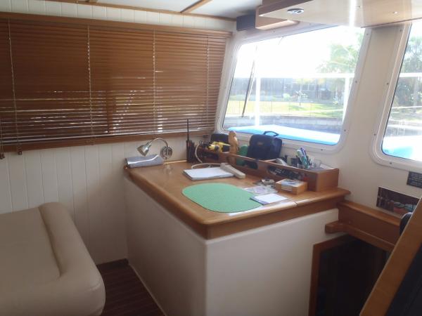 Interior of 2025 Great Harbour N40 boat with desk, window, and wooden blinds.