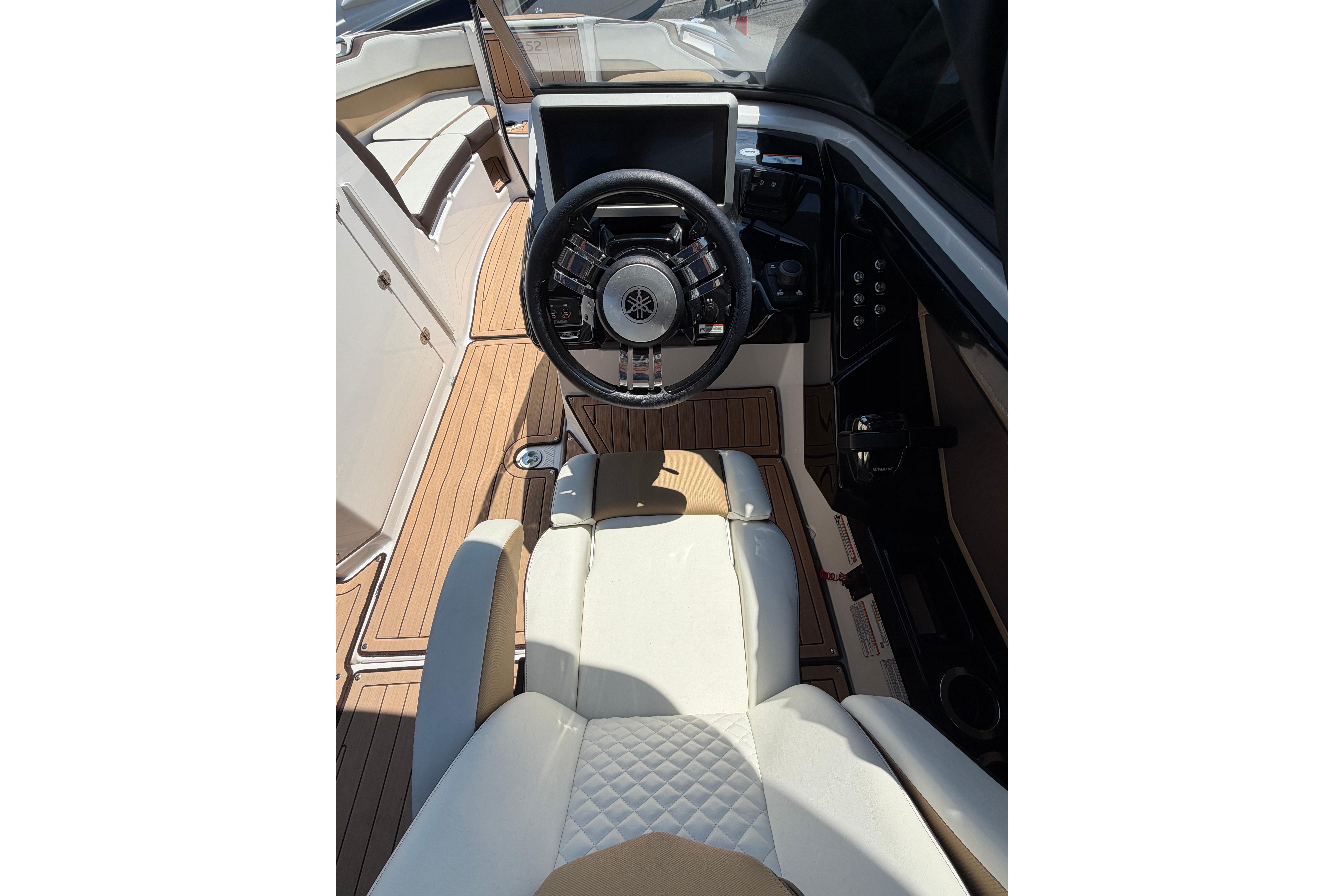 2022 Yamaha Boats 252SD cockpit with steering wheel and luxurious seating.