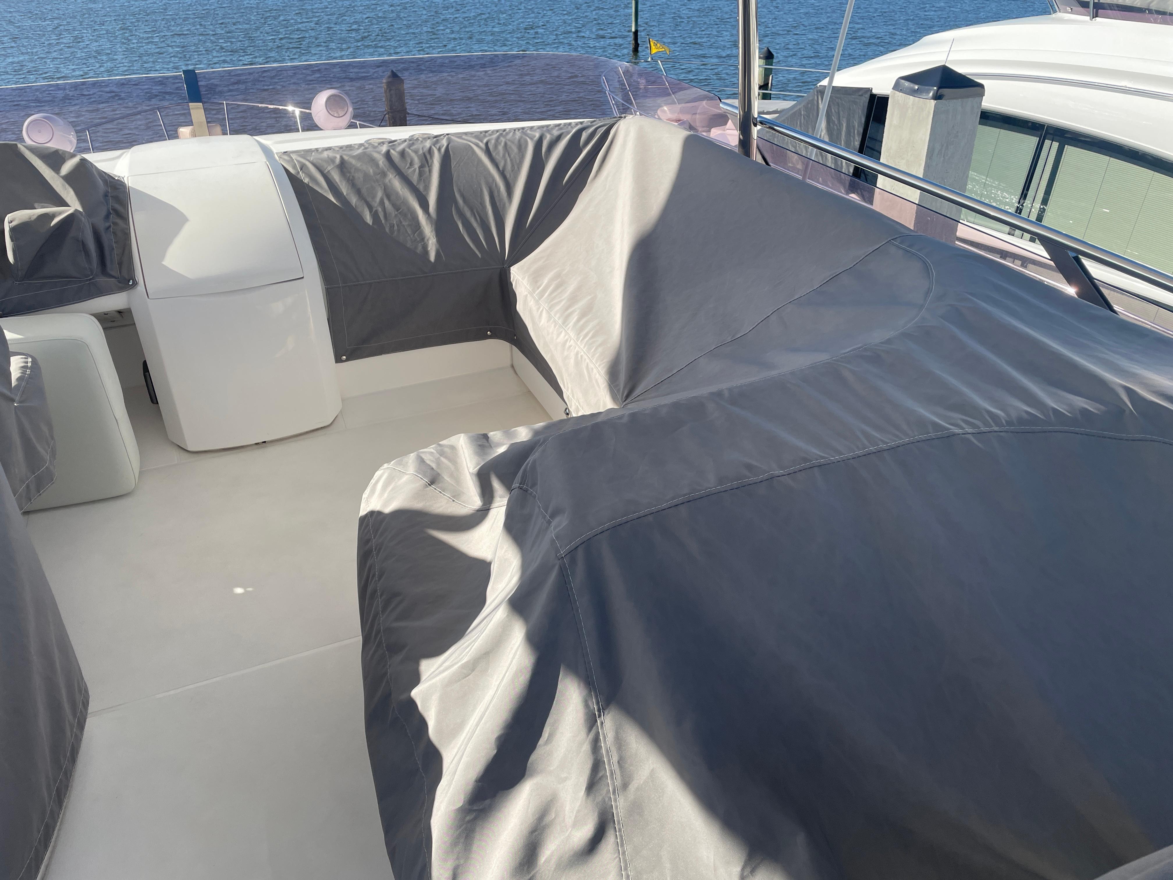 Covered seating area on a 2015 Princess f56 yacht, docked by the water.