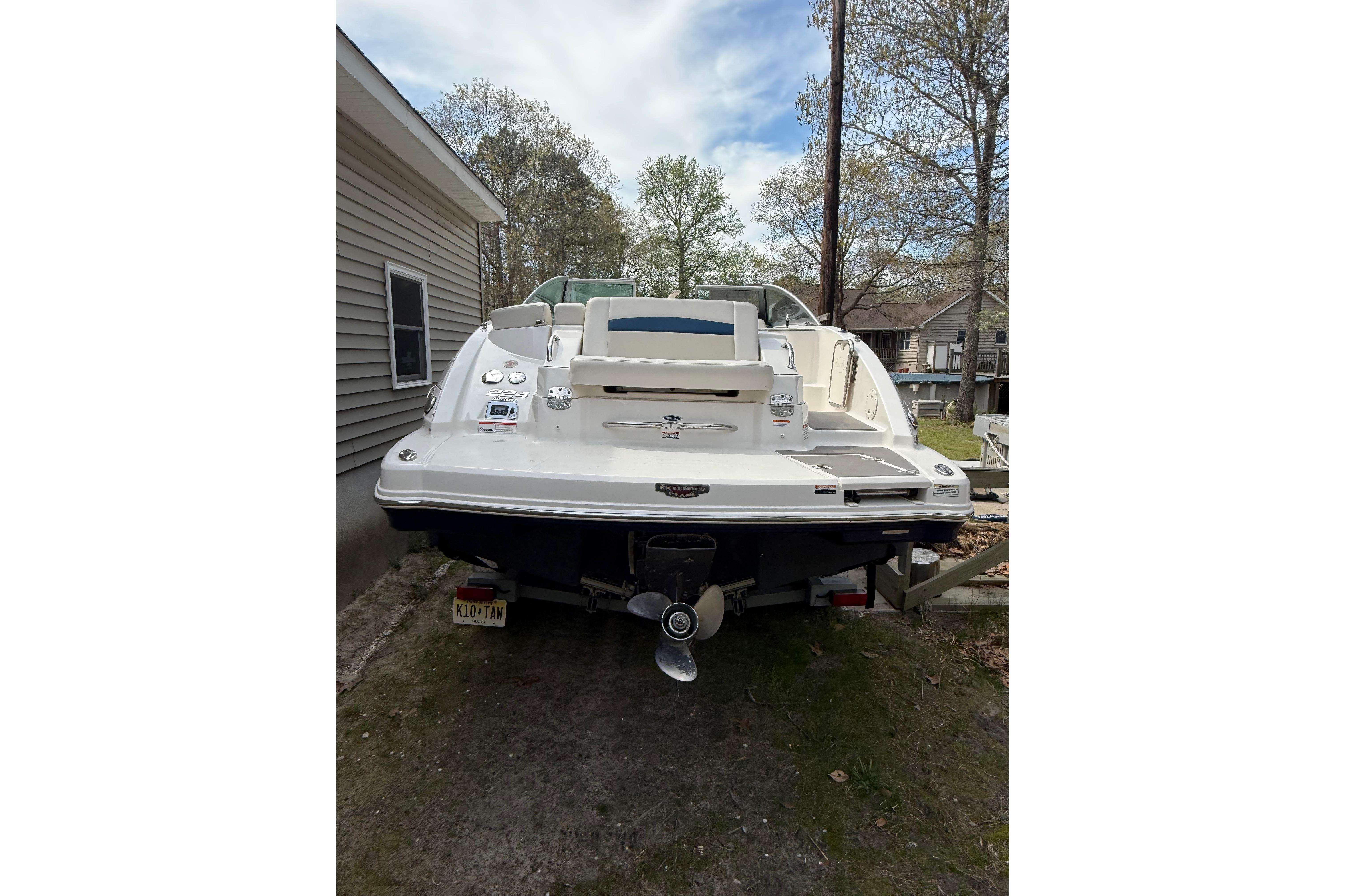 2016 Chaparral 224 Sunesta boat parked outdoors, rear view with trees in background.