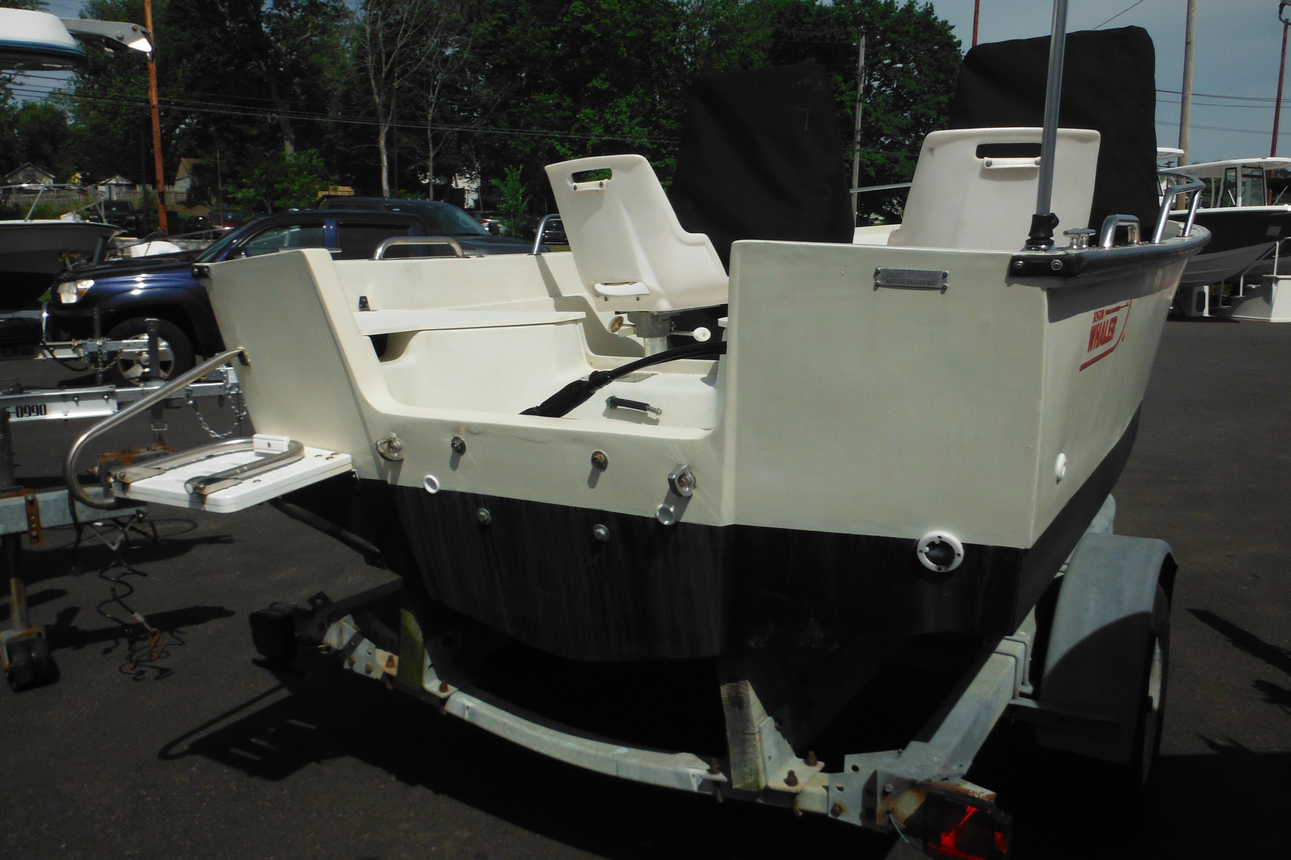 1991 Boston Whaler 16 SL boat on trailer, parked outdoors.