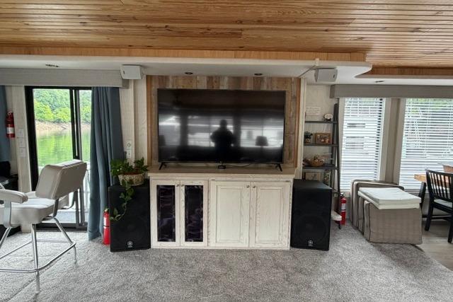Interior of a 1997 Stardust Houseboat 18x83 with modern entertainment setup and cozy seating.