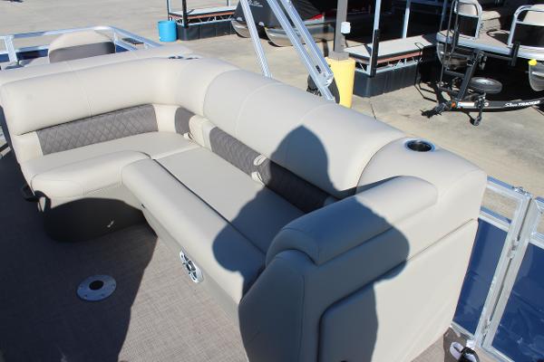 2025 Sun Tracker Fishin' Barge 22 DLX with beige seating and cup holders.