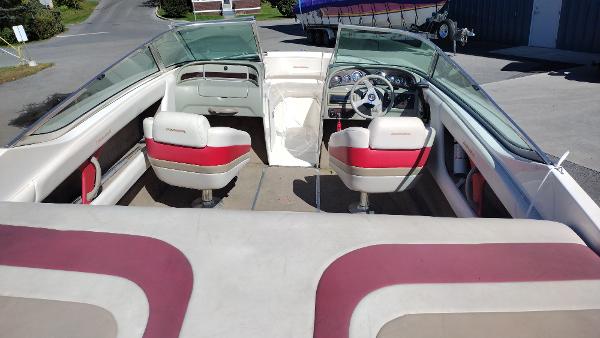1999 Chaparral 2130 SS boat interior with red and white seating, steering wheel, and dashboard.