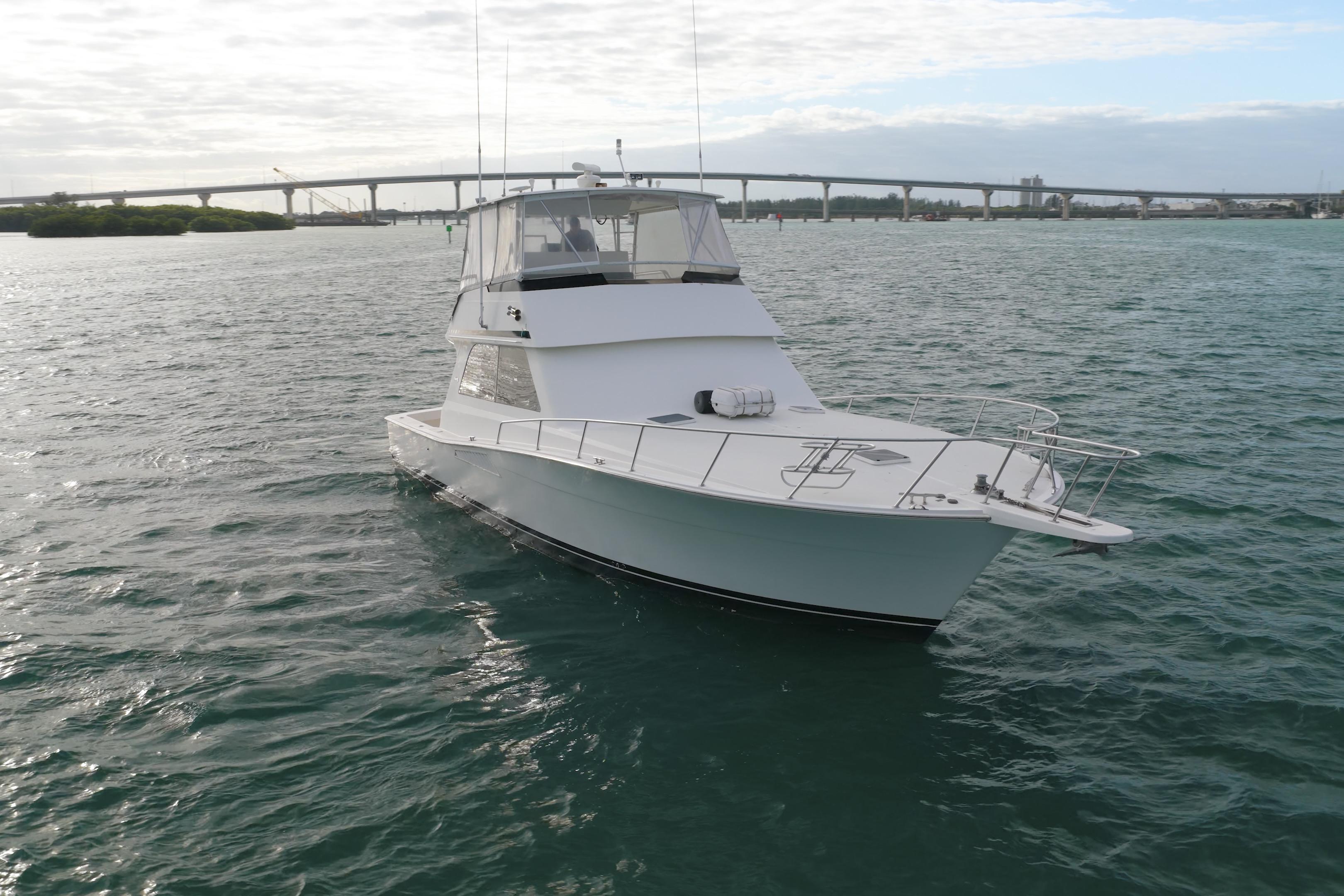 1996 Viking 50 Sport Fisher Convertible yacht on open water near a bridge.