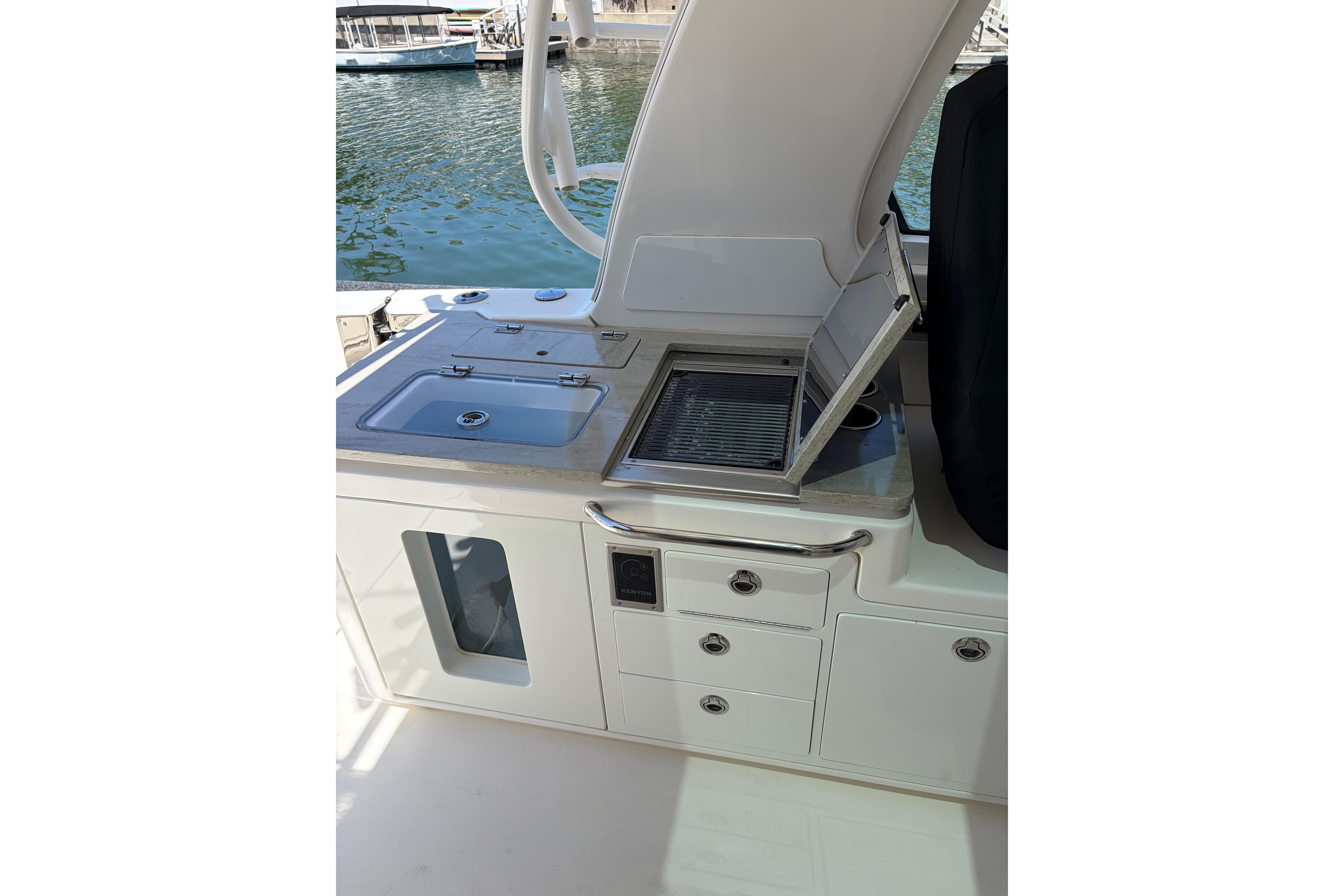 Outdoor kitchen on 2020 Boston Whaler 380 Realm boat, featuring sink and grill.