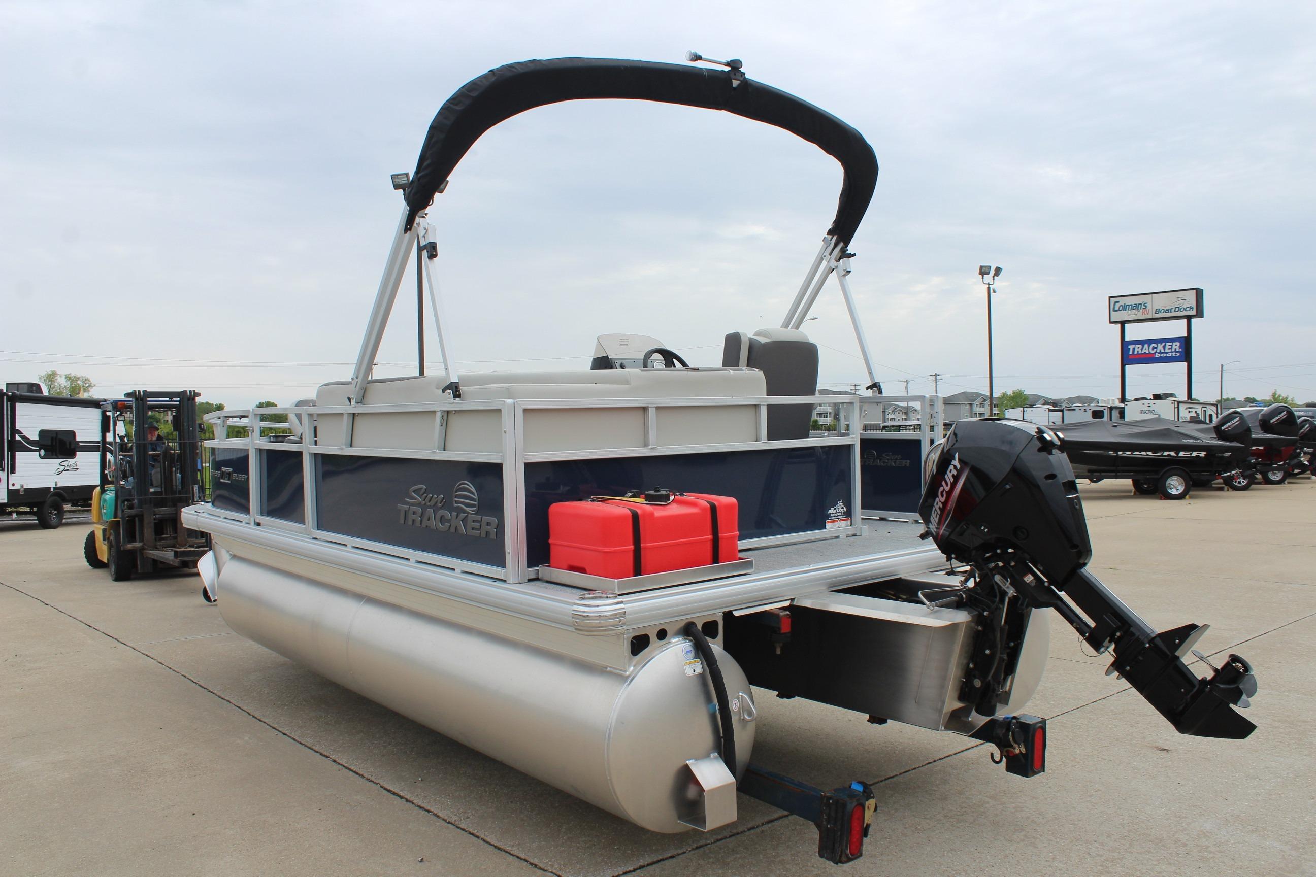 2026 Sun Tracker Bass Buggy 16 XL Select pontoon boat with outboard motor in a dealership lot.
