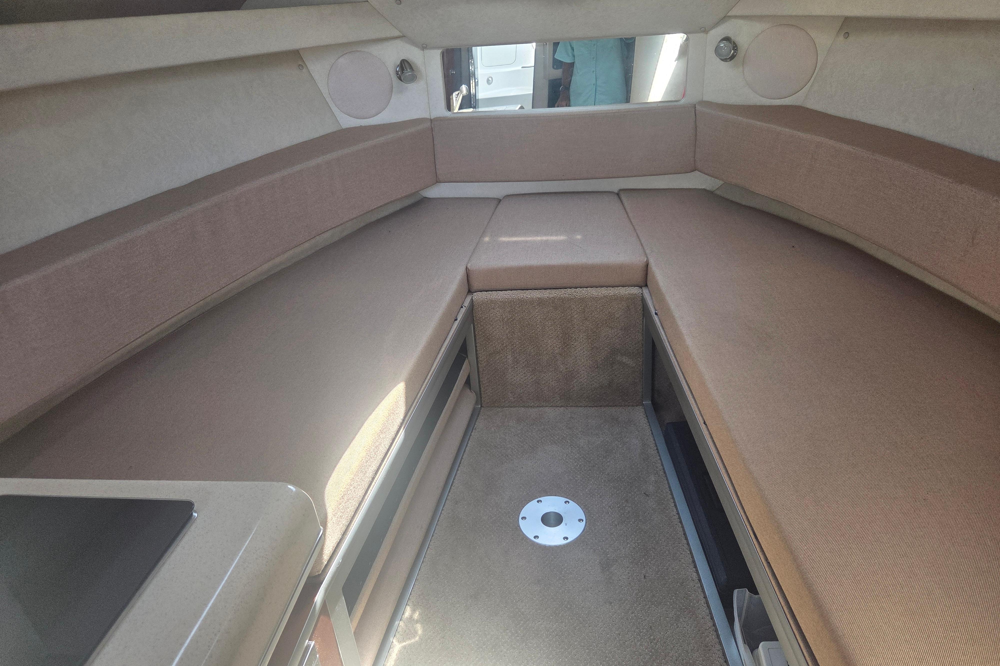 Interior cabin of a 2012 Sea Ray Sundancer 260 boat, featuring beige seating.