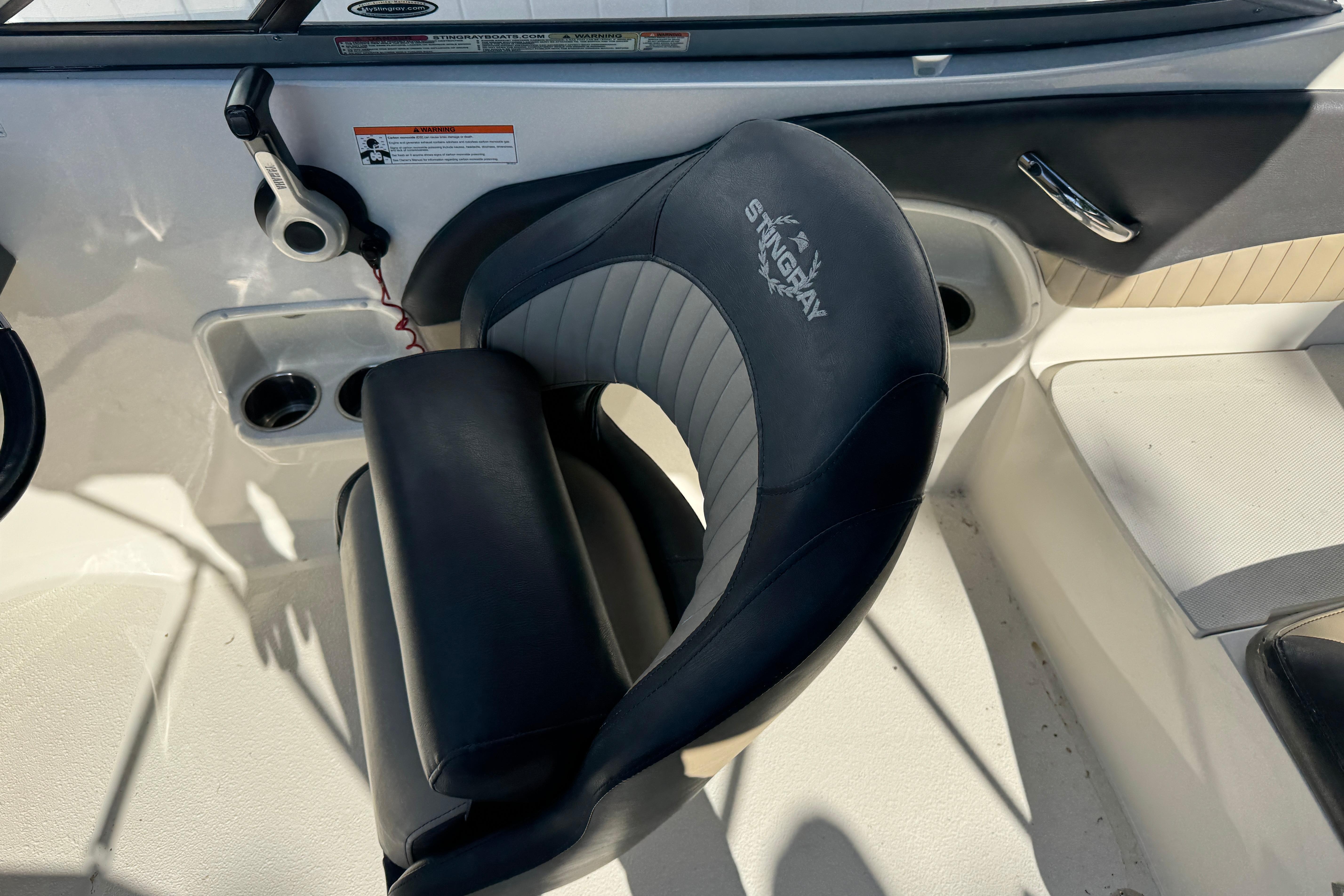 Captain's seat of a 2018 Stingray 204 LR boat, featuring ergonomic design and controls.