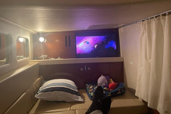 Cozy cabin interior of 2008 Sea Ray 330 Sundancer with TV and comfortable seating.