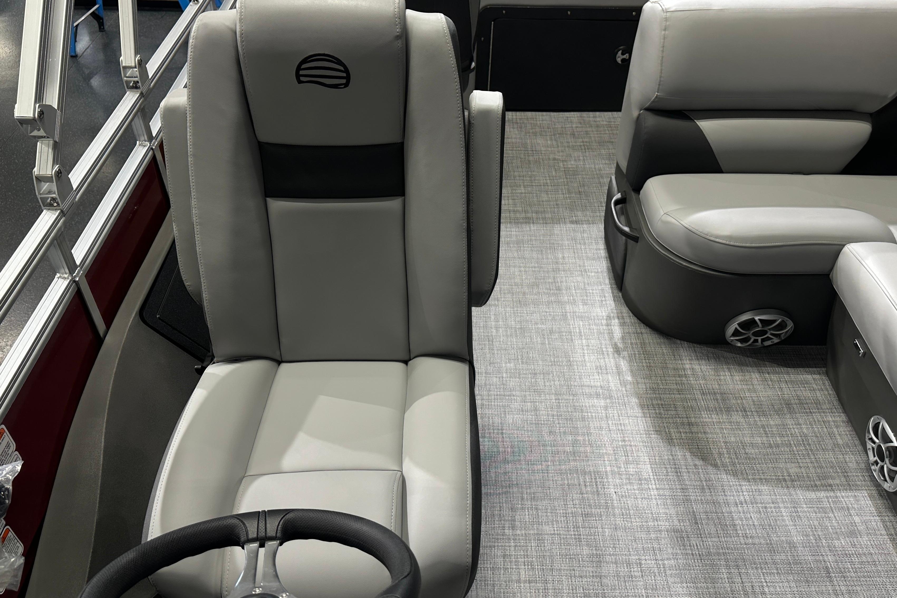 2026 Sun Tracker SportFish 22 DLX interior with gray seating and steering wheel.