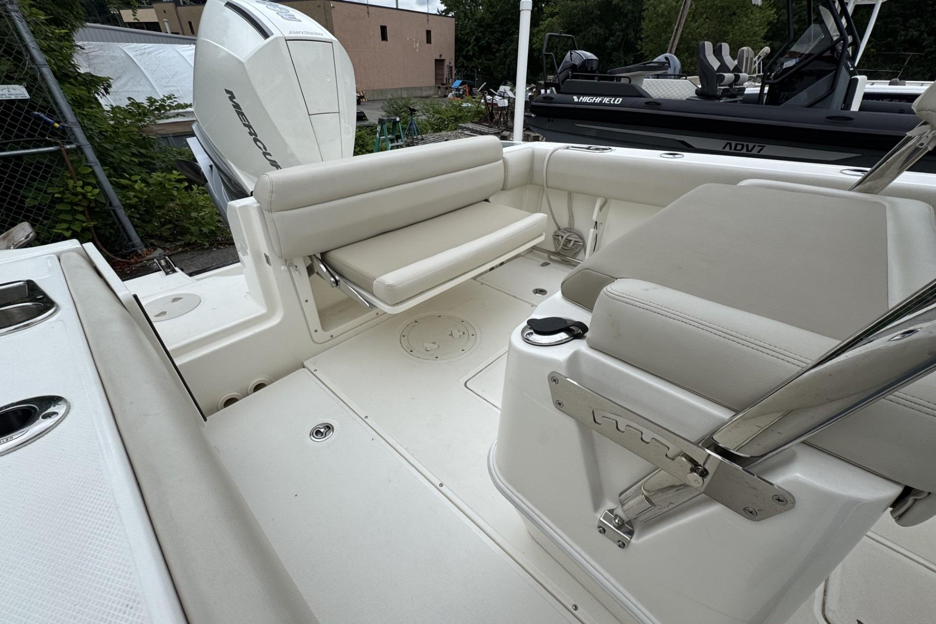2024 Boston Whaler 230 Outrage boat interior with seating and Mercury engine.