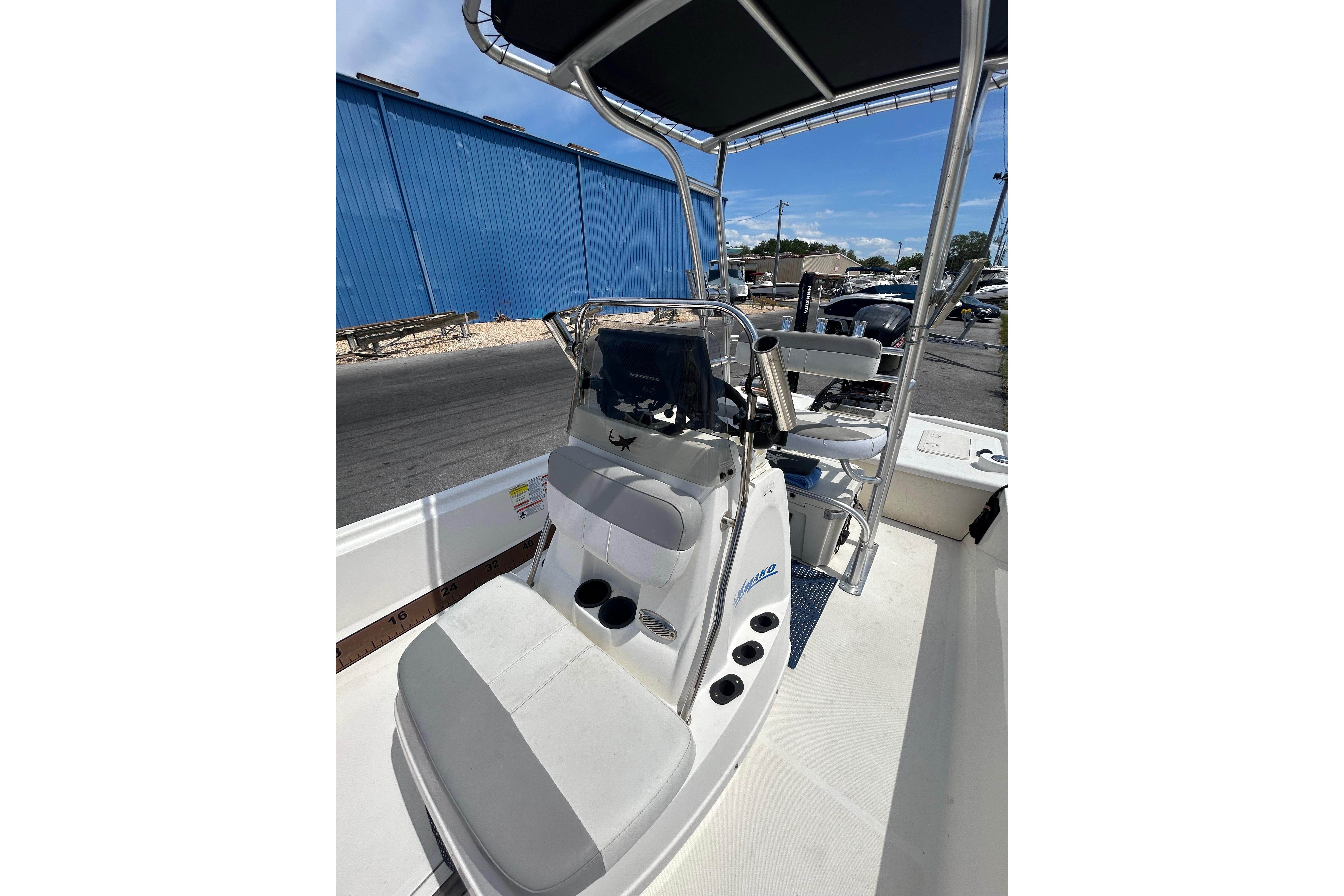 2021 Mako Pro Skiff 19 CC boat interior with console and seating, docked outdoors.