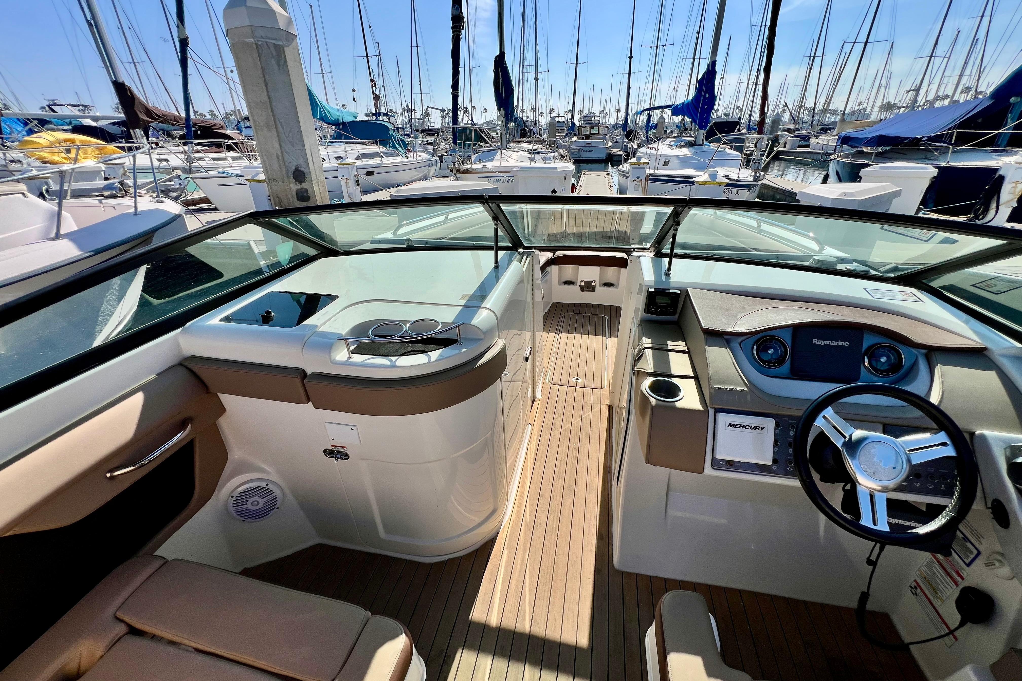 2016 Sea Ray 290 Sundeck Outboard interior with steering wheel, dashboard, and marina view.