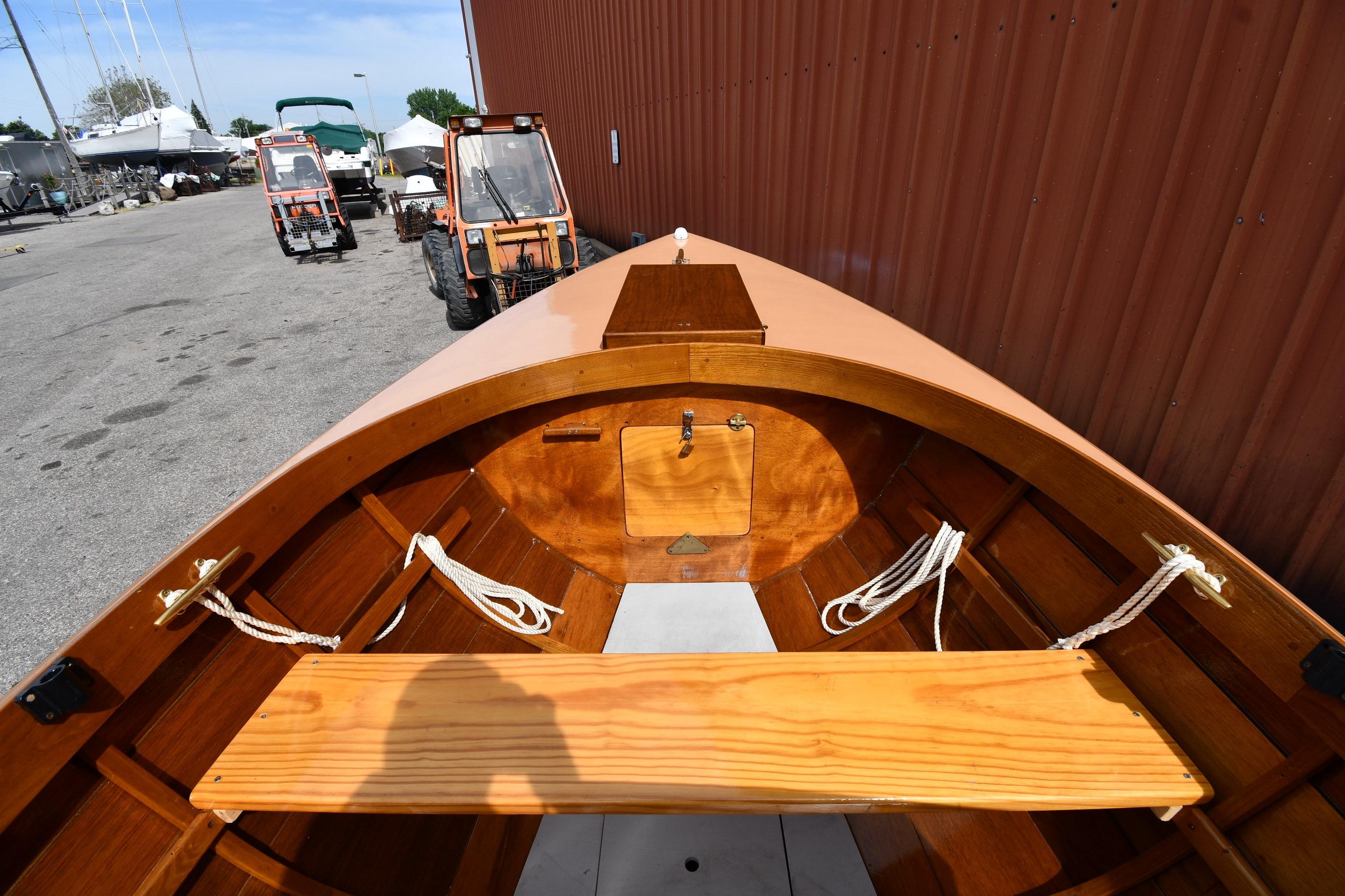 2003 Great Lakes 16 Skiff boat interior with wooden seating and ropes, docked near tractors.