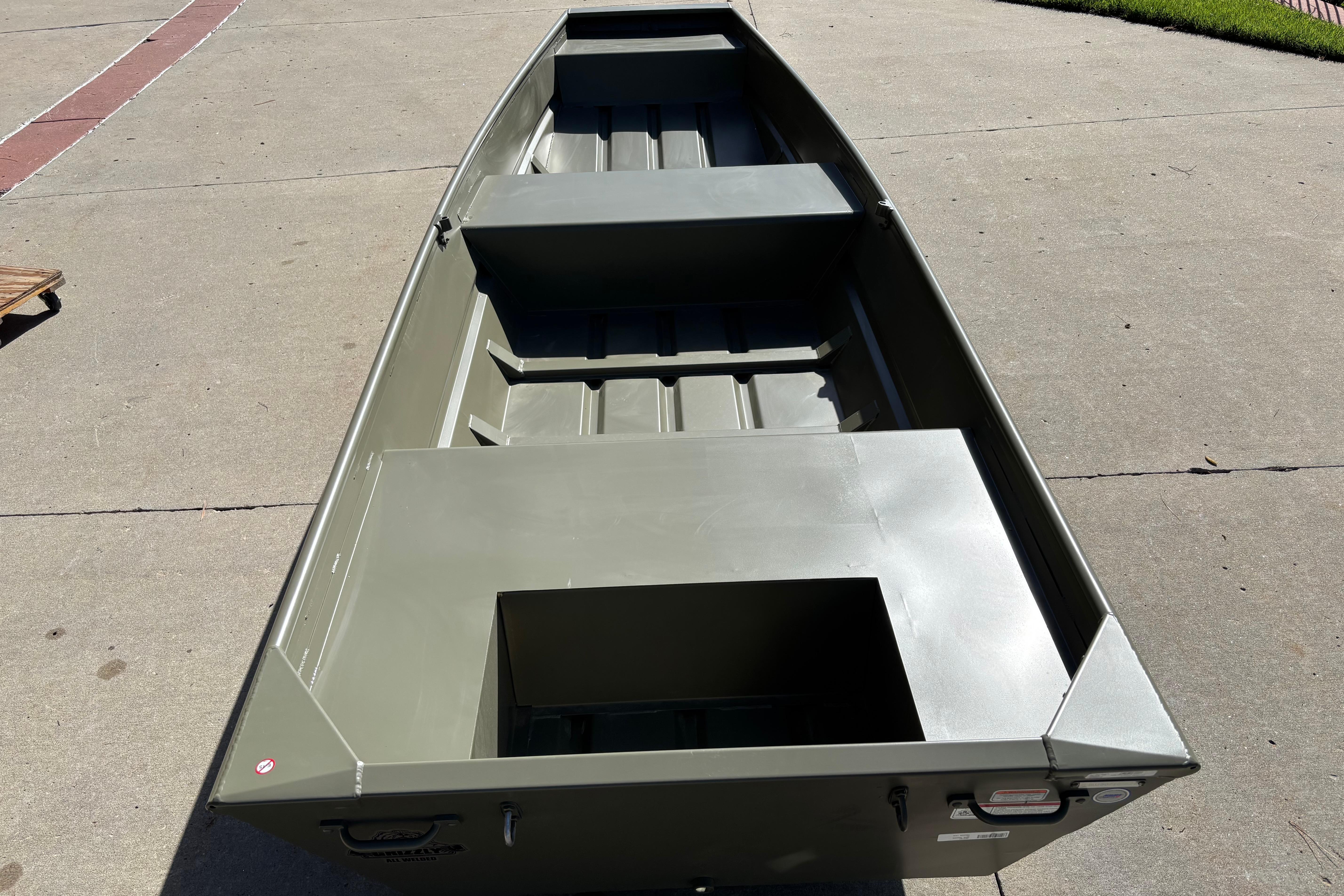 2026 Tracker Grizzly 14 Jon boat on concrete surface, showcasing interior layout and design.